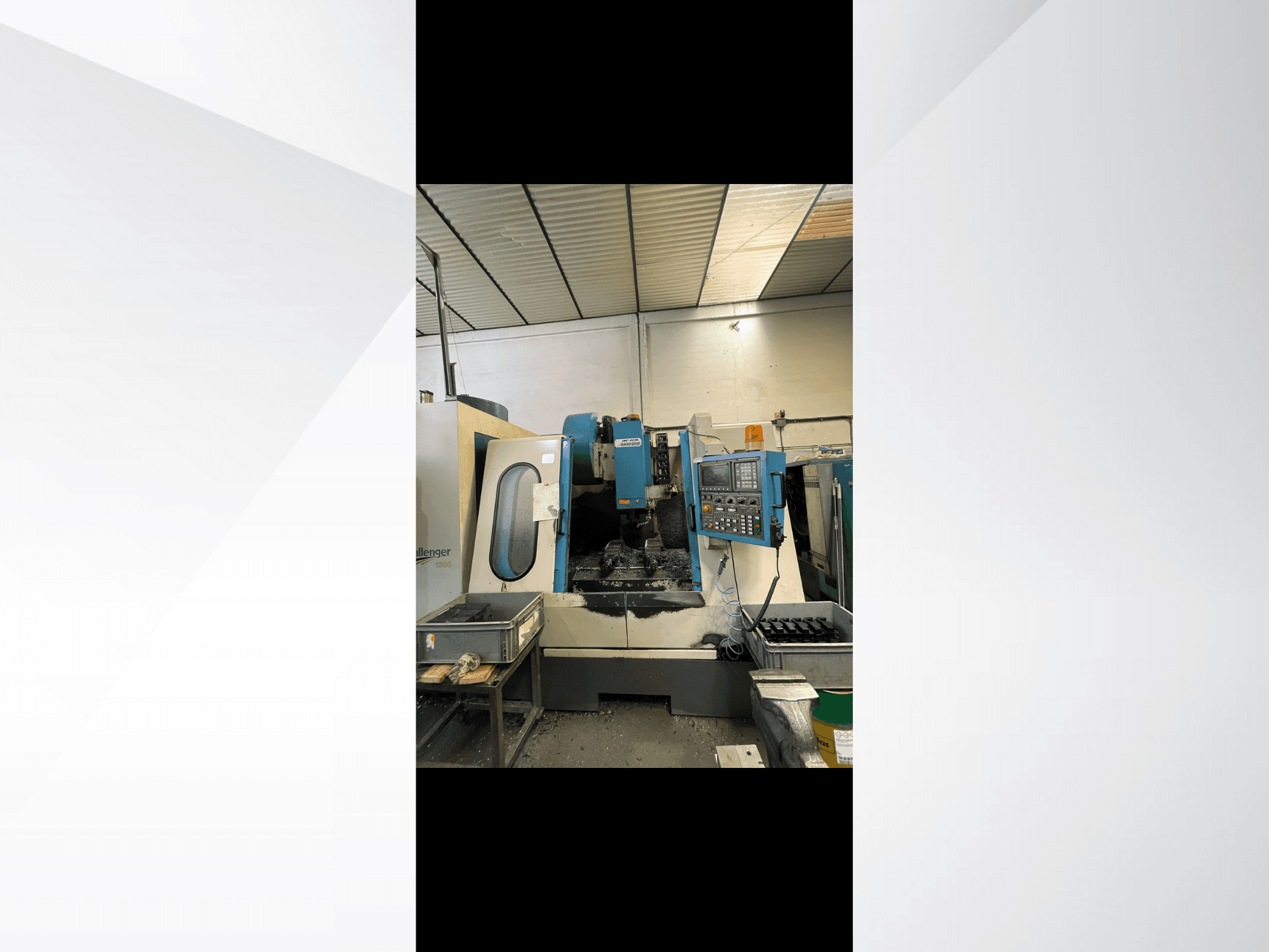CNC staklės, modelis "Challenger 1500", šoninis vaizdas, kuriame matomas valdymo skydelis ir darbo vieta su metalo drožlėmis.