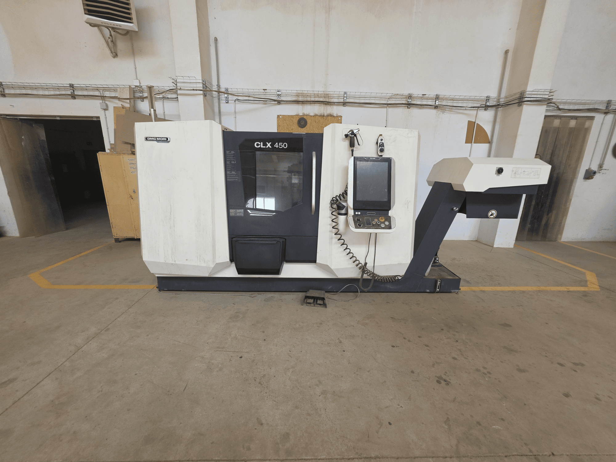 Horizontalus DMG MORI CLX 450 V4 tekinimo staklių vaizdas, kuriame matomas valdymo skydelis, suklio zona ir švari pramoninė aplinka.