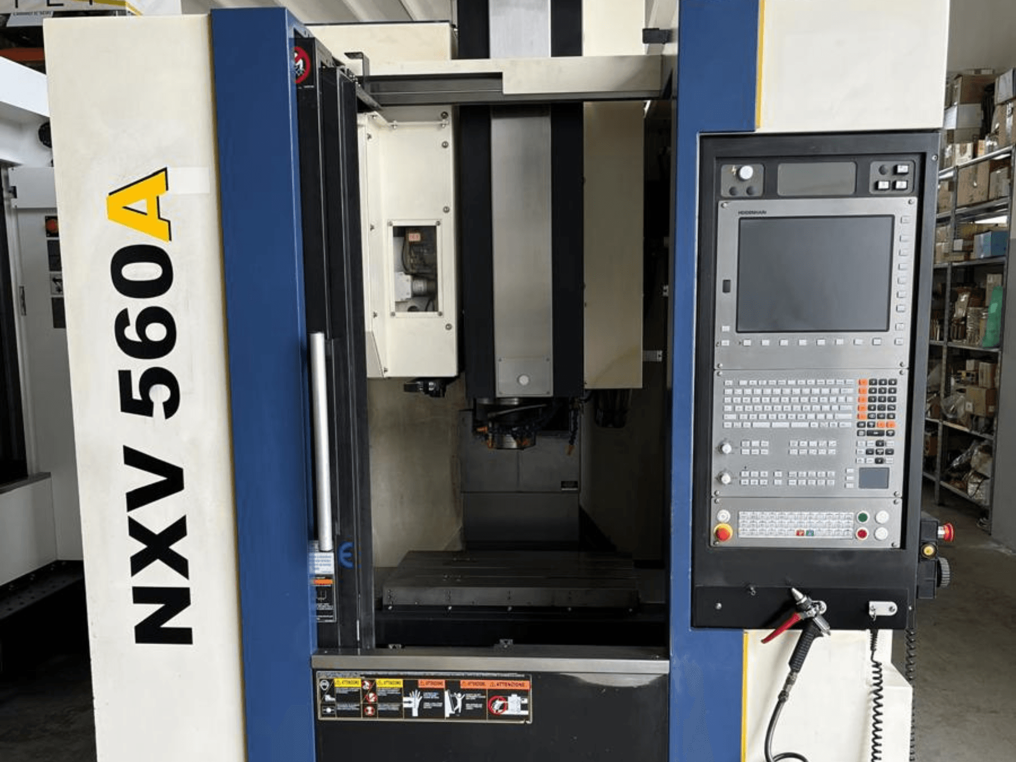 CNC staklės NXV 560A, žiūrint iš priekio, su valdymo skydeliu su mygtukais ir skaitmeniniu ekranu.