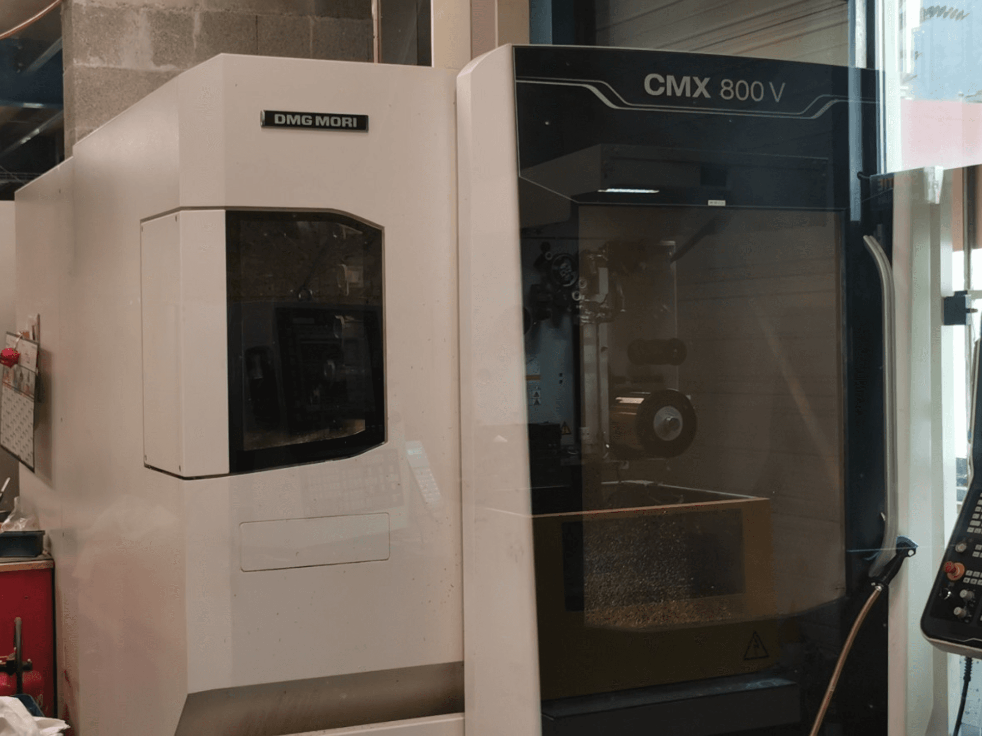Vertikalusis apdirbimo centras „DMG Mori Seiki CMX 800 V“, vaizdas iš priekio, kuriame matomas valdymo pultas ir darbo zona su matomais įrankiais.