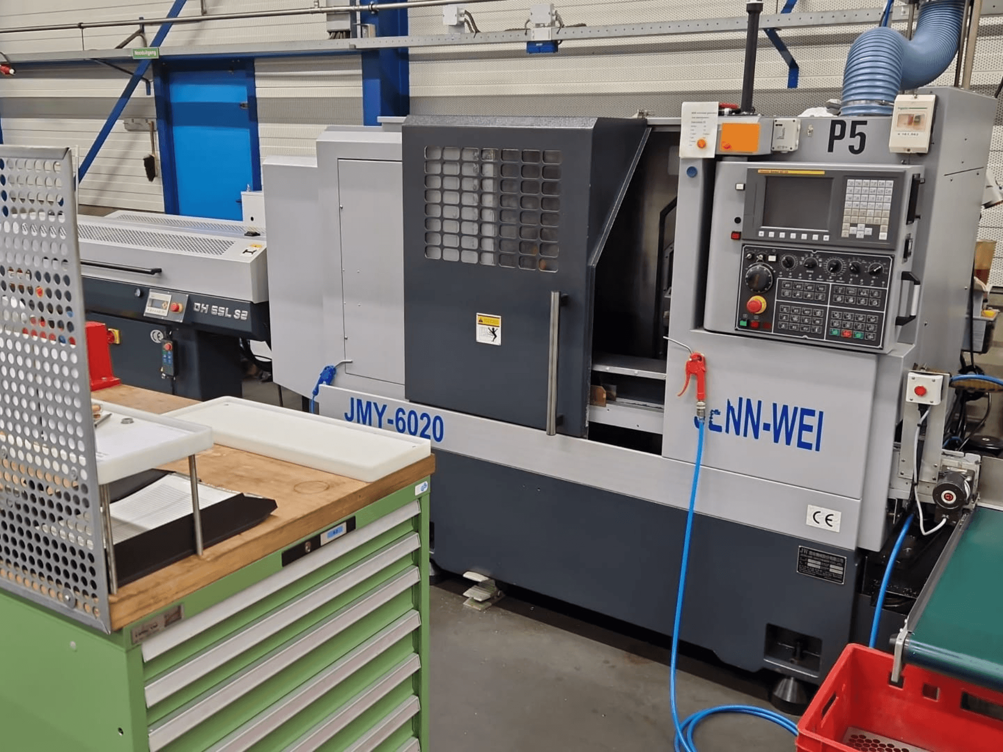 CNC tekinimo staklės, cNN-WEI modelis JMY-6020, žiūrint iš priekio. Valdymo skydelis, avarinis stabdys ir aušinimo skysčio linija.