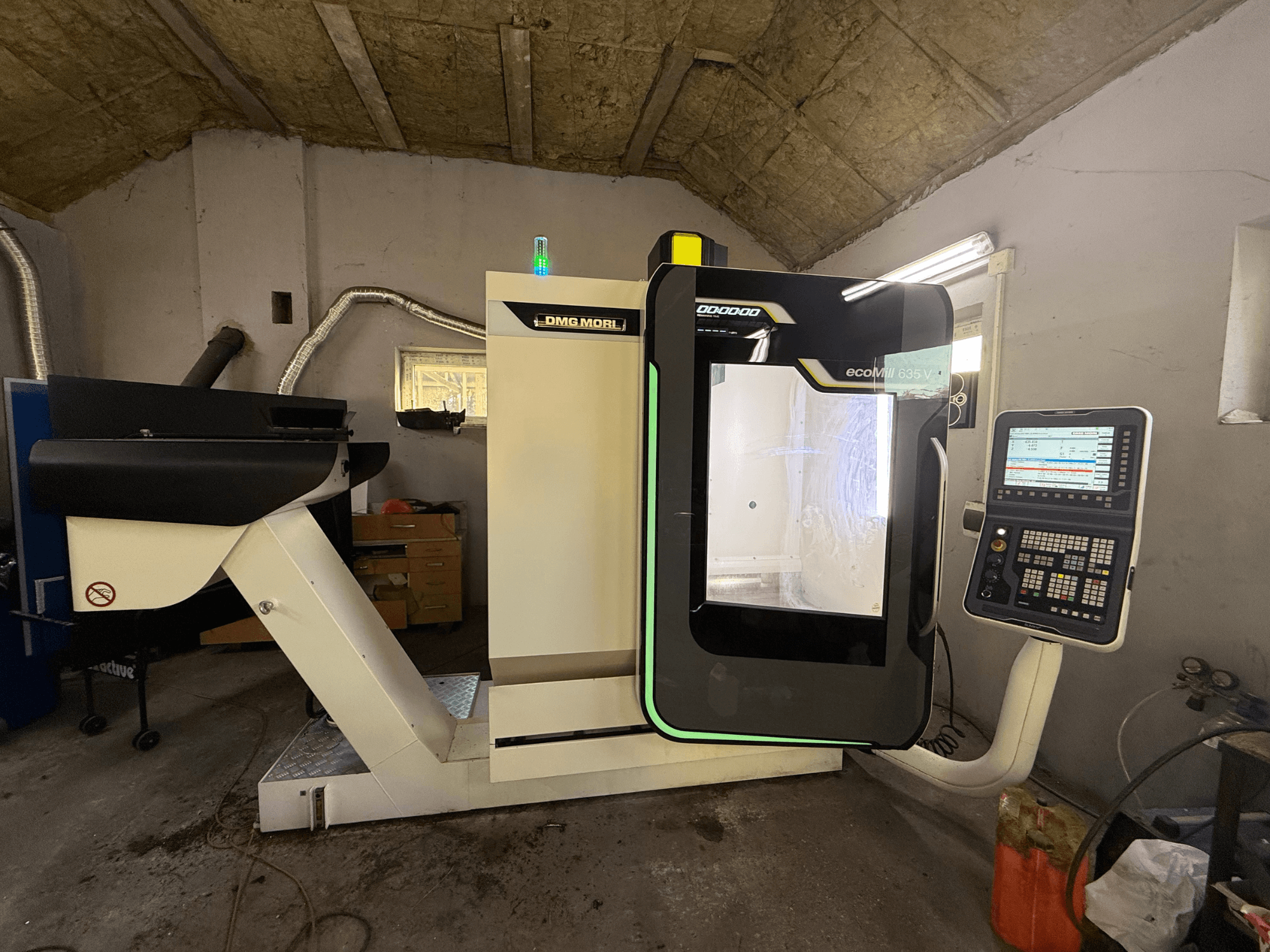DMG 635 V Ecoline vertikalusis apdirbimo centras, vaizdas iš priekio su valdymo skydeliu, kuriame matyti apdirbimo zona ir modernus dizainas.