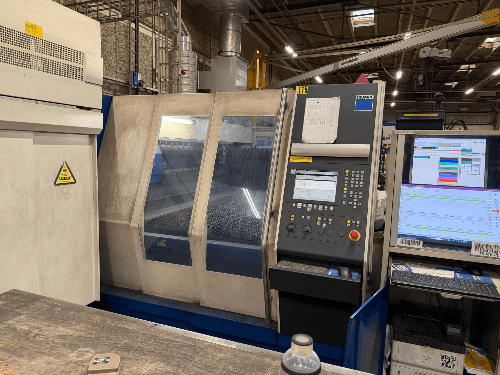"Trumpf" pramoninio lazerinio įrenginio su valdymo skydeliu ir skaitmeniniais ekranais vaizdas iš priekio gamykloje.