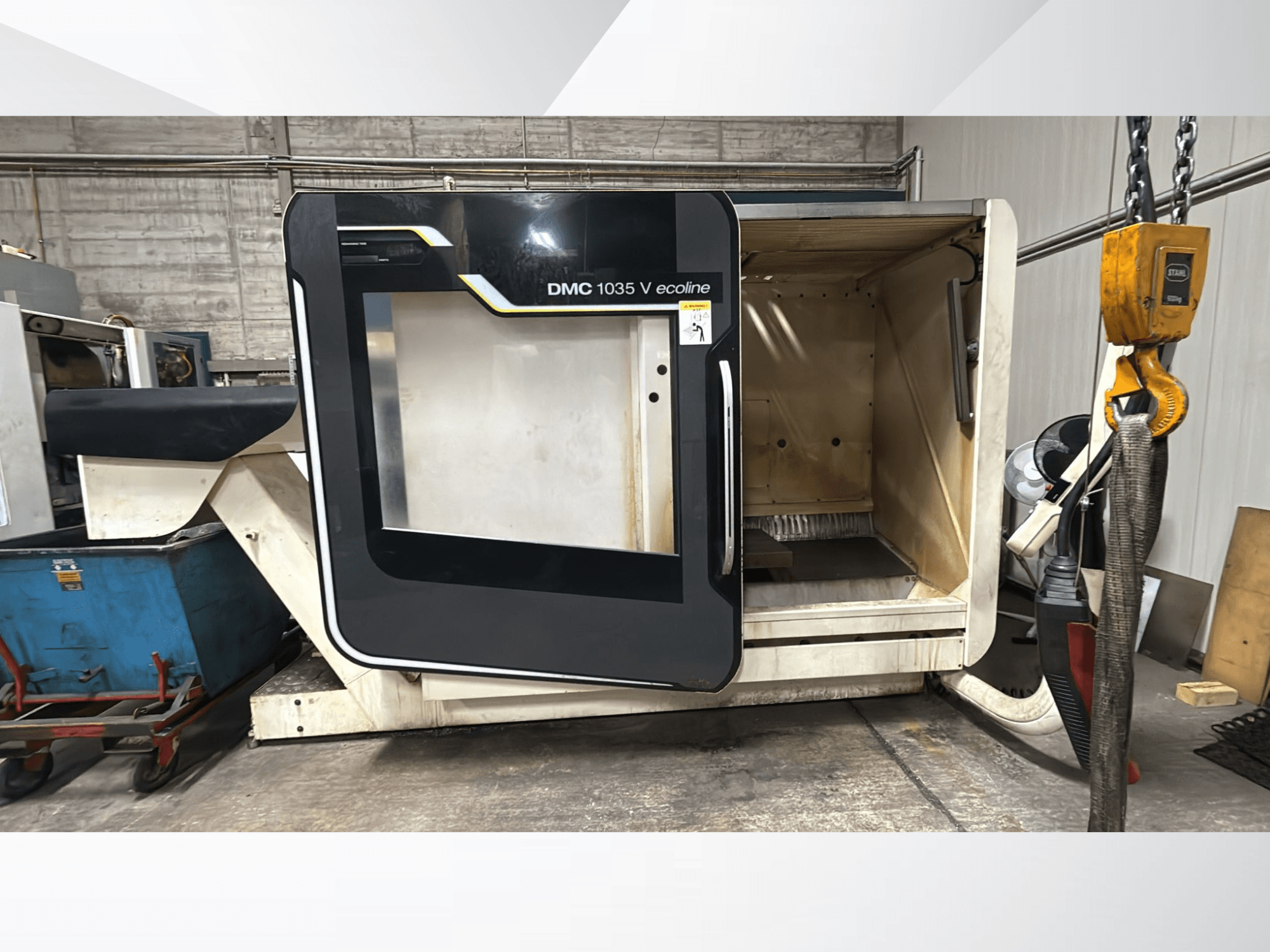DMC 1035 V ecoline CNC staklės, vaizdas iš priekio, atidarytos durys atskleidžia tuščią vidų ir valdymo skydelį.