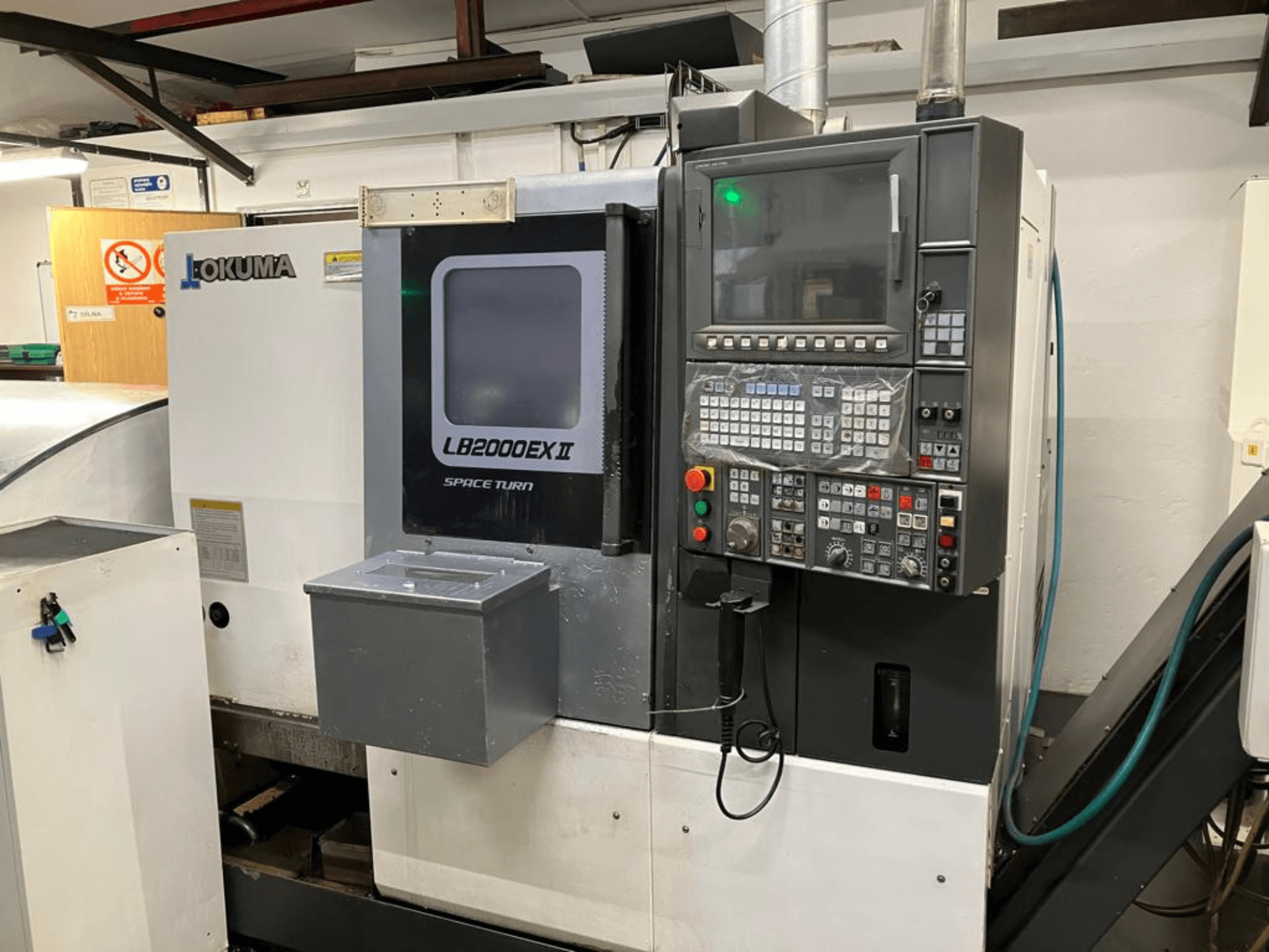 Okuma LB2000EXII MC horizontalios tekinimo staklės, priekinis vaizdas, kuriame matomas valdymo skydelis ir darbinės funkcijos.