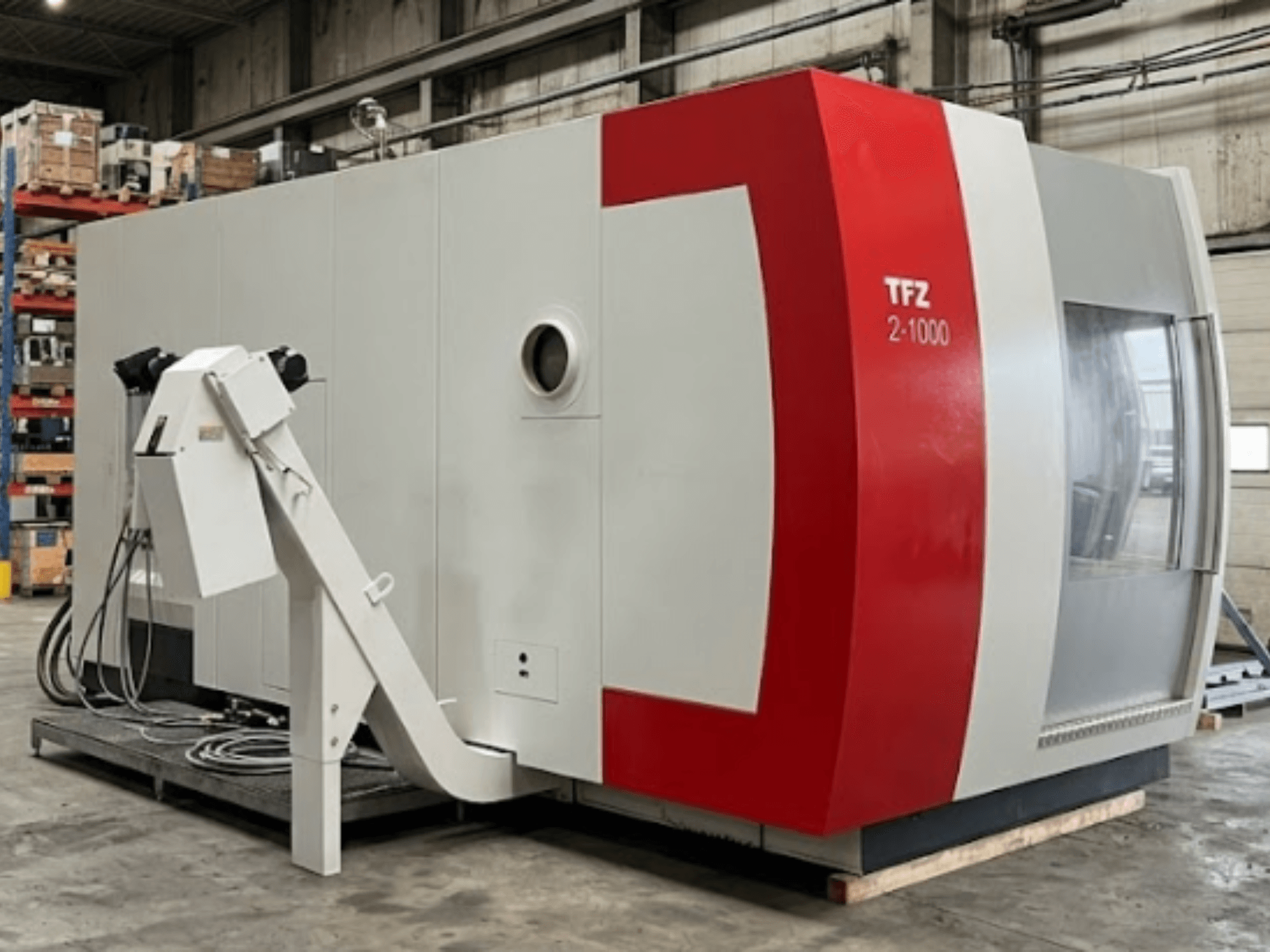Universalus apdirbimo centras „SAMAG TFZ 2L-1000“, šoninis vaizdas, kuriame matyti jo raudonos ir pilkos spalvų dizainas bei pritvirtinta robotinė ranka.