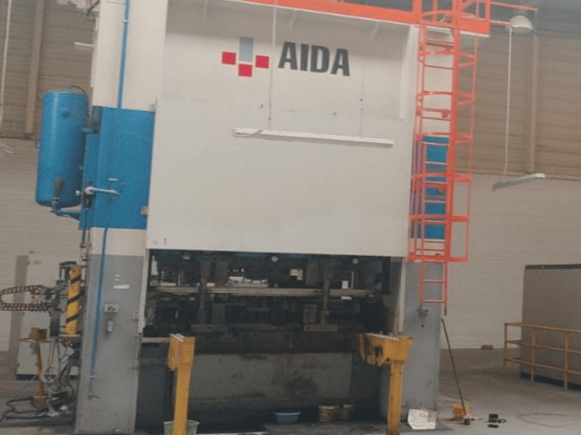 AIDA mechaninio štampavimo presas 315/2MR/LD/TE3, vaizdas iš priekio, hidrauliniai komponentai ir saugos kopėčios.