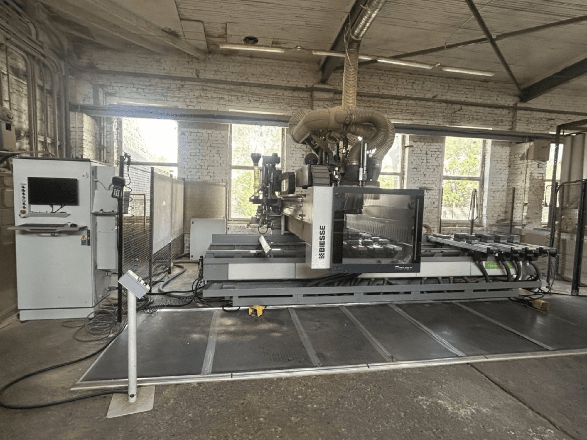 „BIESSE Rover A Edge 1643“ CNC apdirbimo centras, vaizdas iš priekio, kuriame matomas valdymo pultas, darbo stalas ir pramoninė aplinka.
