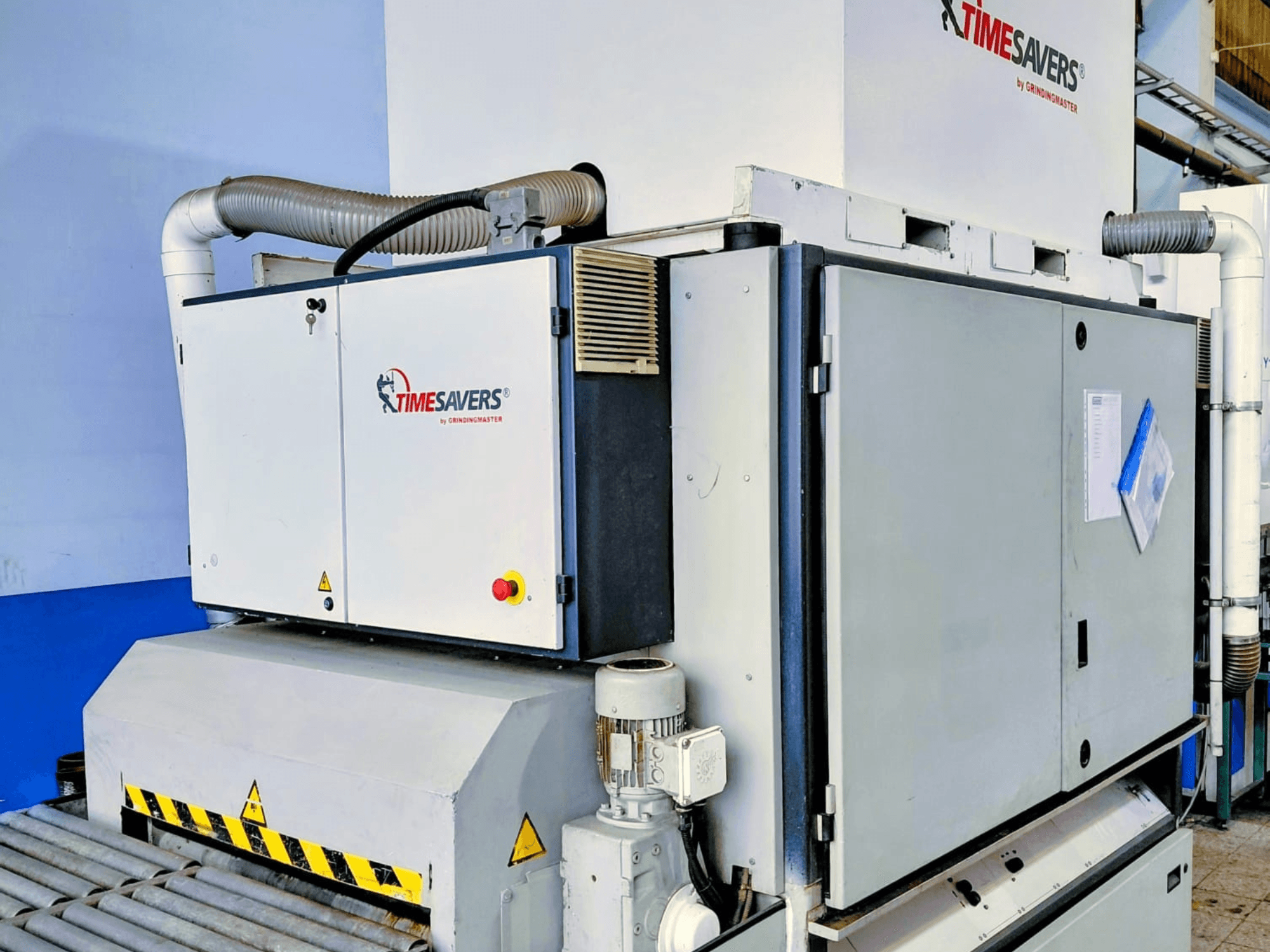 TIME SAVERS pramoninės šlifavimo staklės, vaizdas iš šono, su reguliuojamu voleliu, valdymo skydeliu ir dulkių ištraukimo sistema.