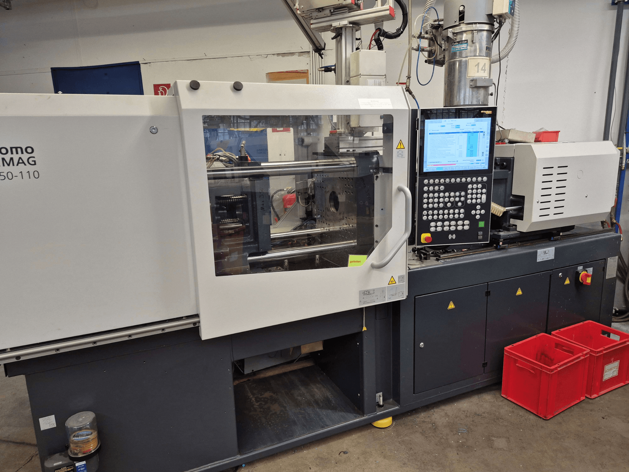 „SUMITOMO SHI DEMAG Intelect 2 50/360-110“ elektrinė liejimo mašina, vaizdas iš šono, kuriame matomas valdymo pultas ir saugos įranga.