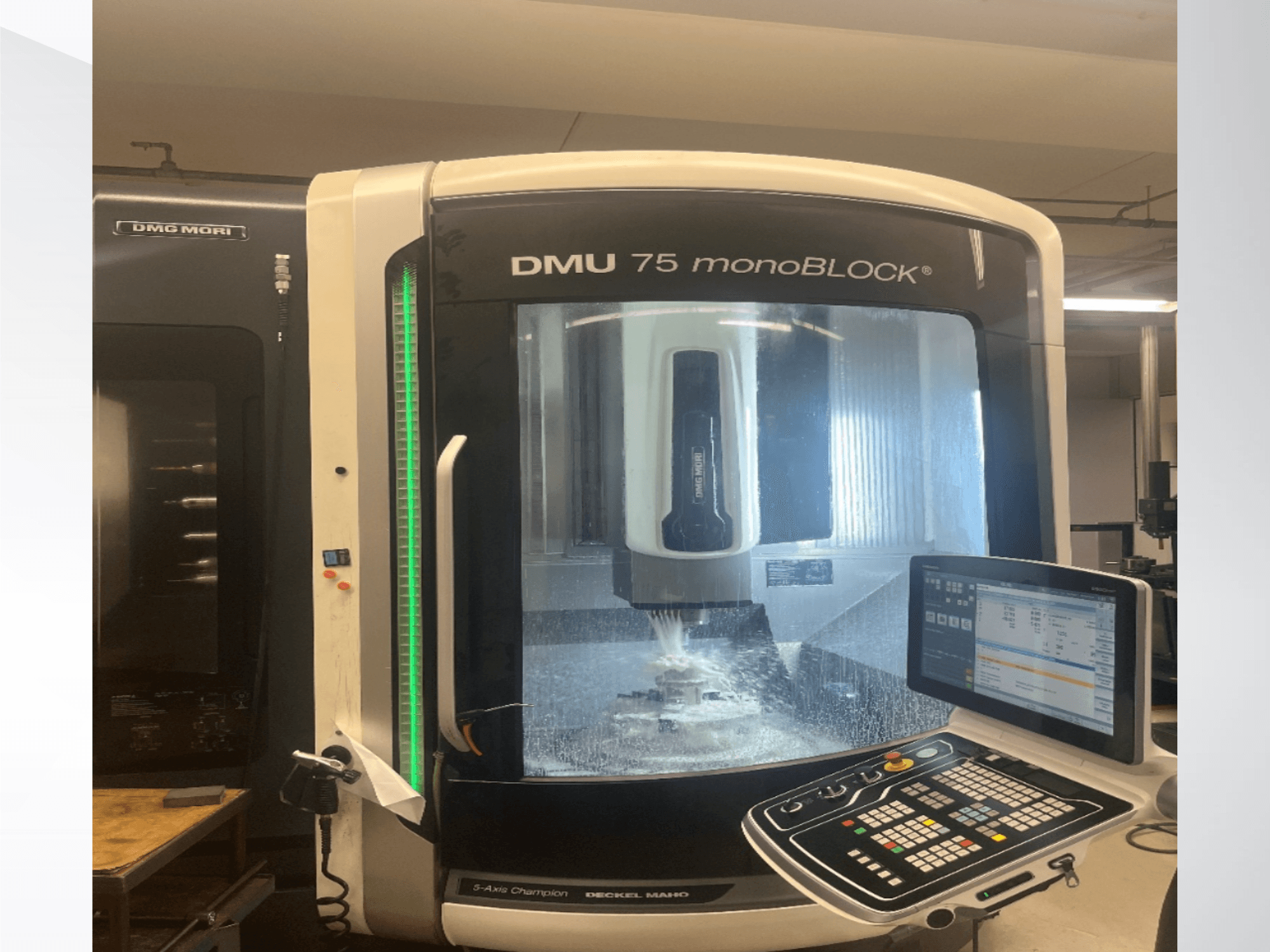 DMG MORI DMU 75 „monoBLOCK“ universalus apdirbimo centras, vaizdas iš priekio, kuriame matomas valdymo pultas ir frezavimo zona.