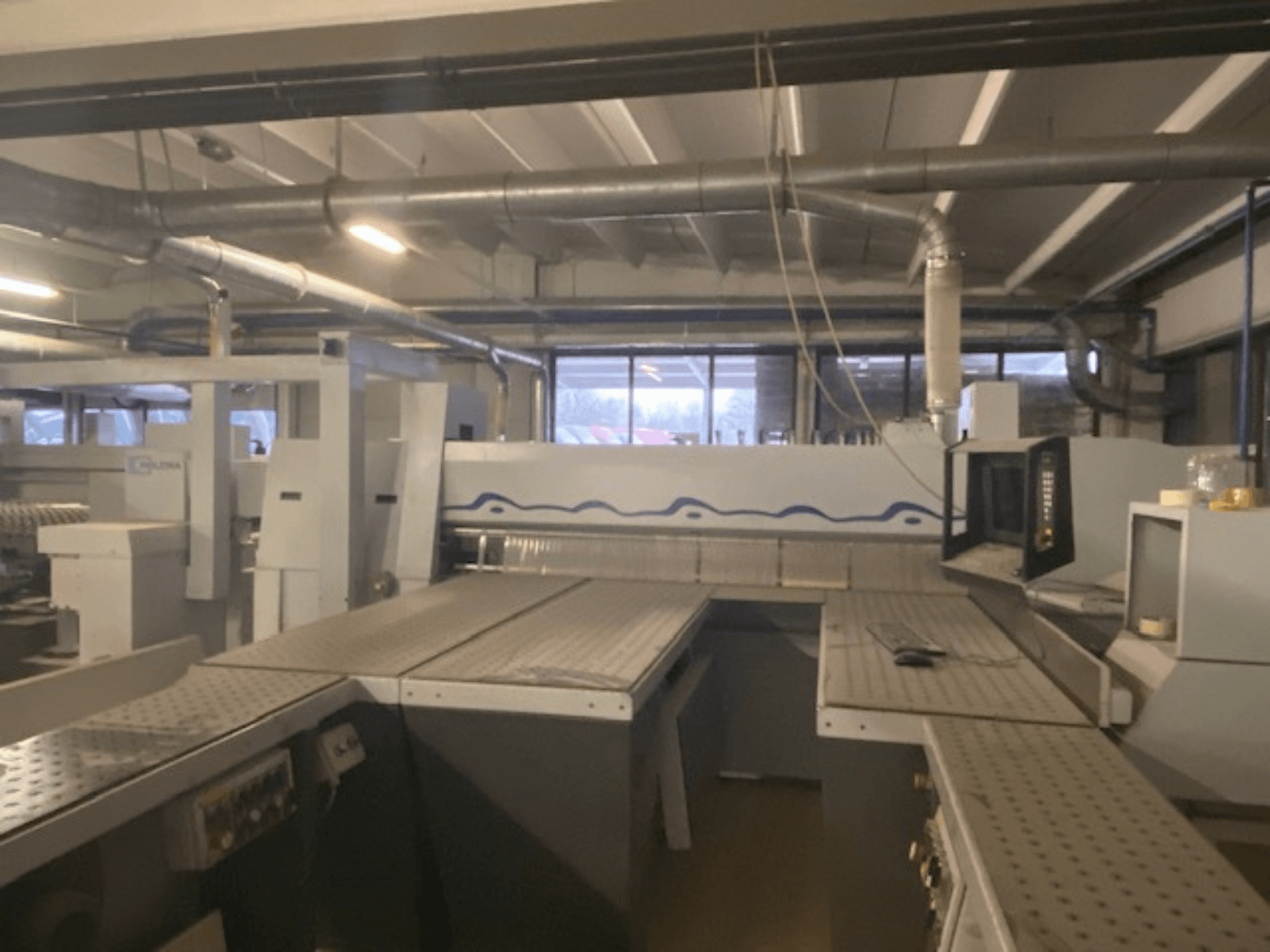 Pramoninė darbo vieta, kurioje yra įrenginys su valdymo skydeliu, žiūrint iš padidinto priekinio kampo.