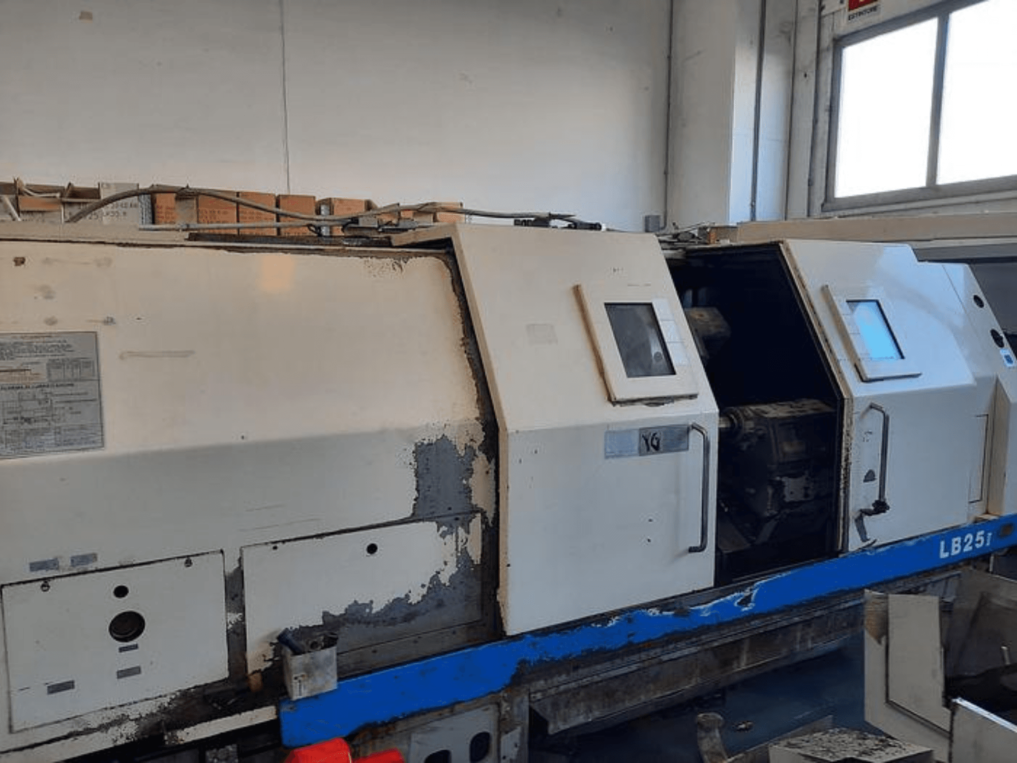 Naudotos LB251 tekinimo staklės, šoninis vaizdas, iš kurio matyti susidėvėjusi išorė, atidarytas skydelis, kuriame matomas vidinis mechanizmas ir valdymo įtaisai.