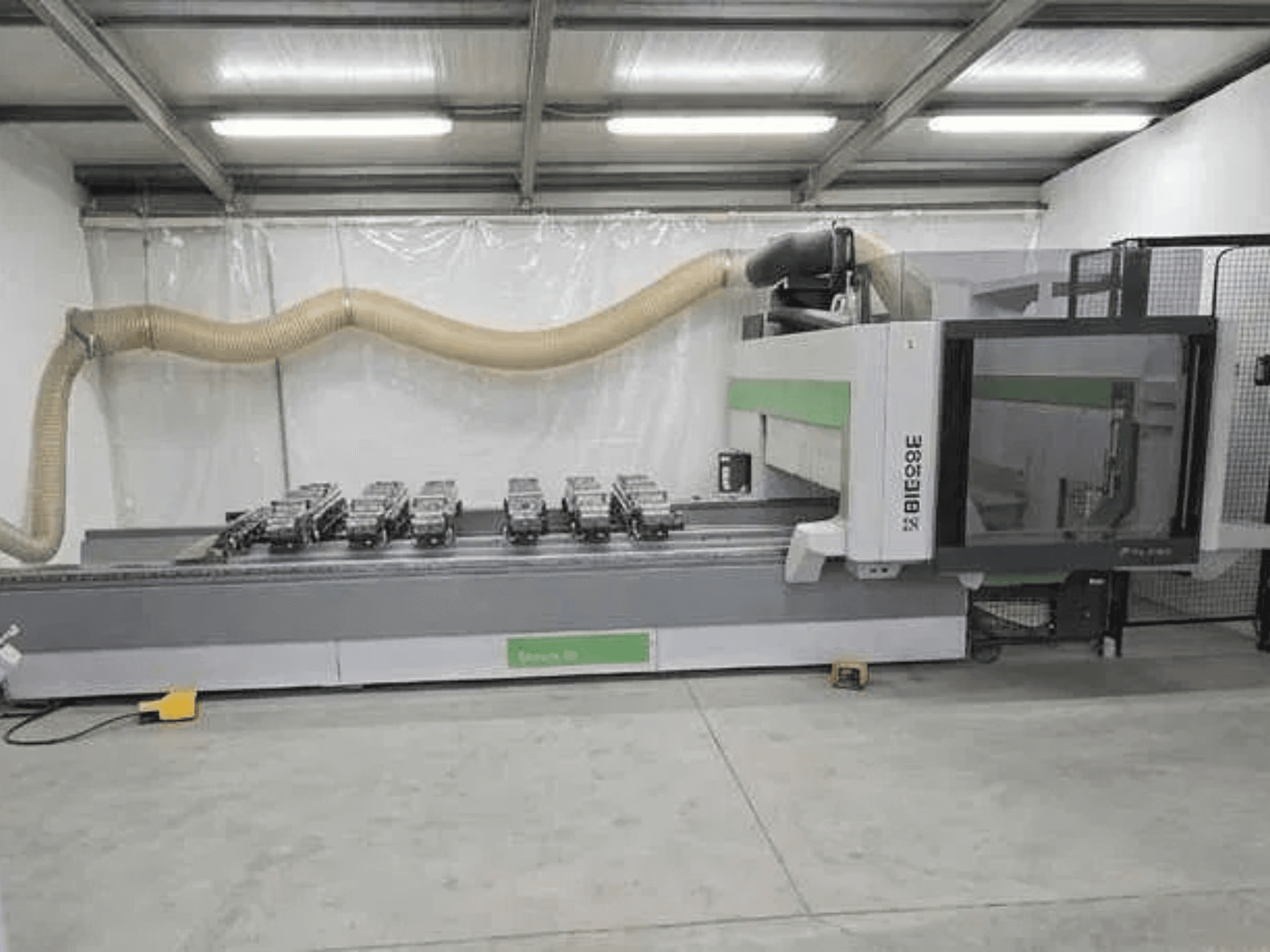 „BIESSE Rover K1232“ CNC apdirbimo centras, vaizdas iš šono, kuriame matomos vakuuminės siurbtuvės ir dulkių surinkimo sistema.