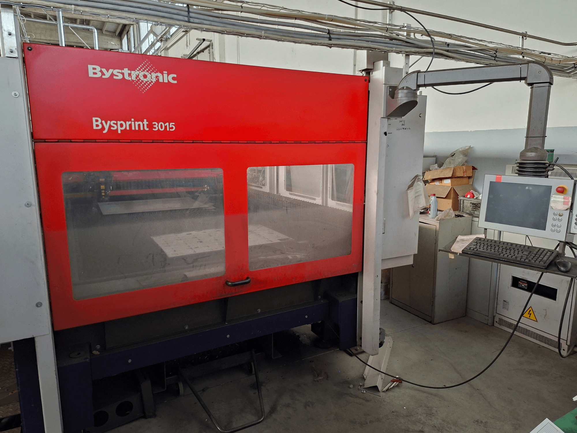 „Bystronic Bysprint 3015“ CO₂ lazerio pjovimo staklės, vaizdas iš priekio, kuriame matomas valdymo skydas ir lazerio pjovimo zona.