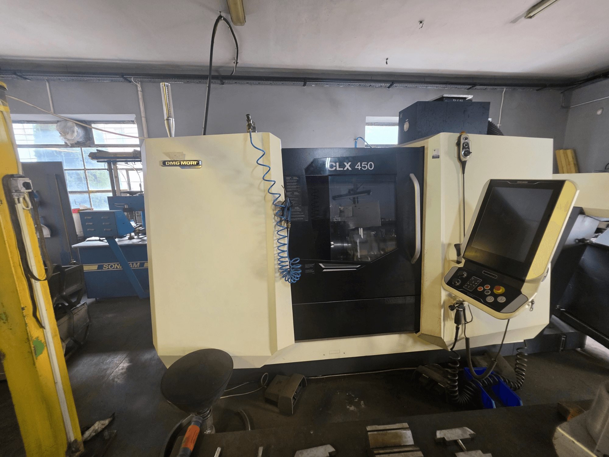 DMG MORI CLX 450 V6 horizontalios tekinimo staklės, vaizdas iš priekio, su valdymo pultu ir matomu prekės ženklu.