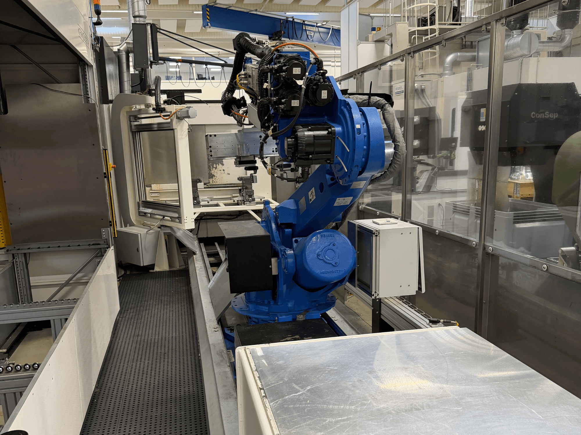 "Yaskawa Motoman ES165D" roboto ranka ant bėgio, šoninis vaizdas, rodantis automatizavimo sąranką pramoninėje aplinkoje.