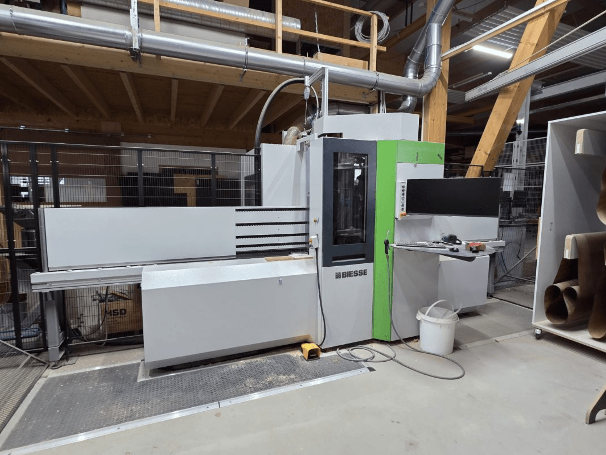 „BIESSE Brema EKO 2.2“ CNC apdirbimo centras, vaizdas iš priekio, kuriame matomas valdymo skydas ir pagrindinis korpusas su žaliais akcentais.