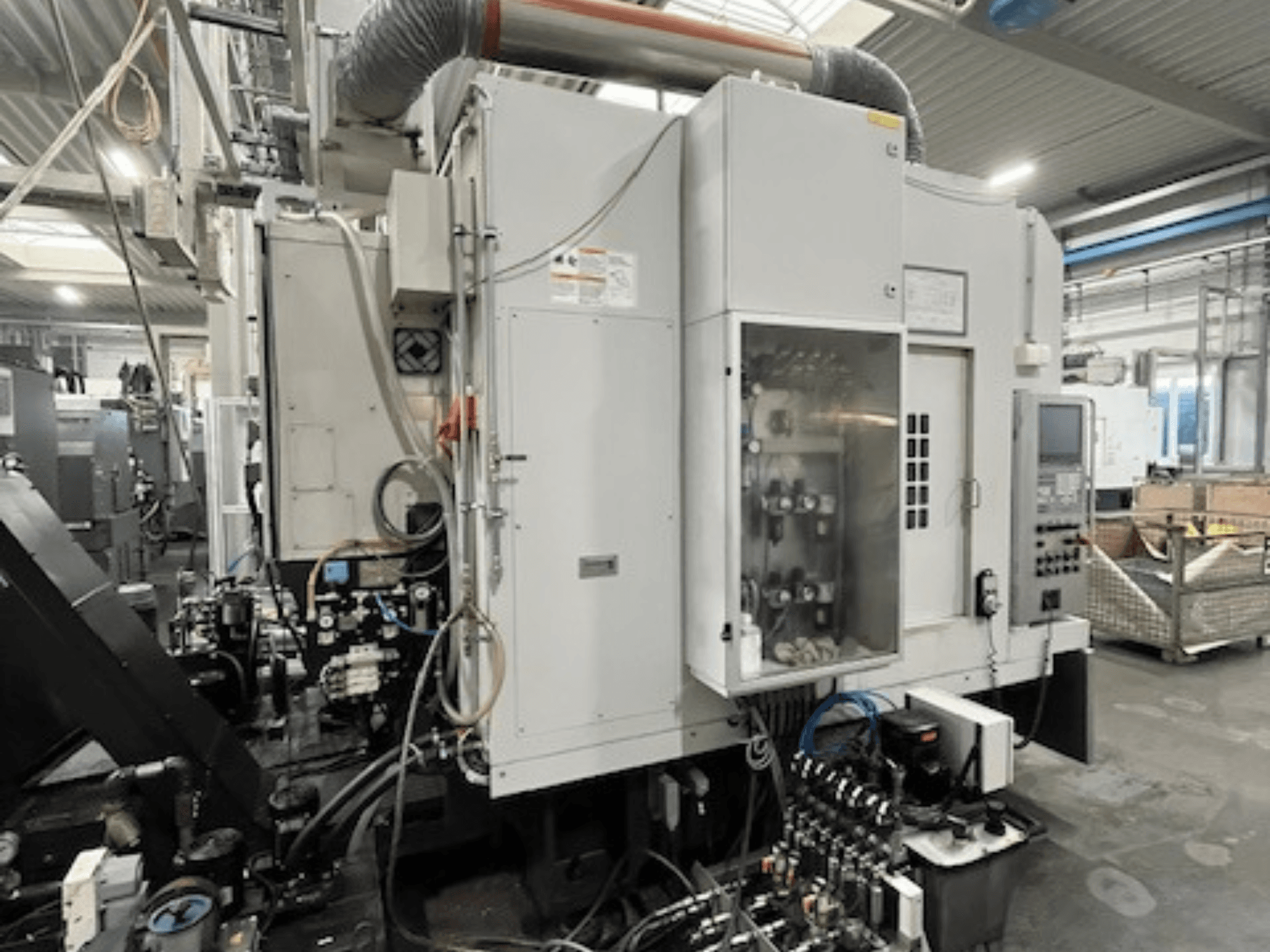 Pramoninės mašinos šoninis vaizdas su valdymo skydeliu ir hidrauliniais komponentais, pateikiama prekės ženklo ir modelio informacija.