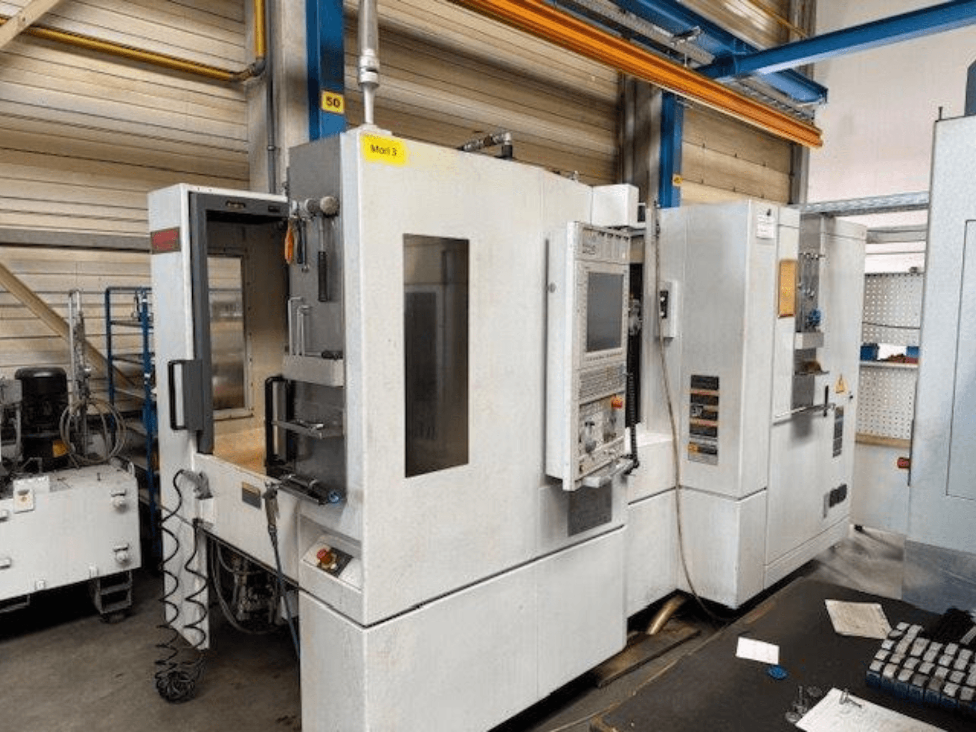 MORI SEIKI NH4000 DCG horizontaliojo apdirbimo centro priekinis vaizdas su atidarytomis durelėmis ir matomu valdymo skydeliu, rodančiu darbinę erdvę.