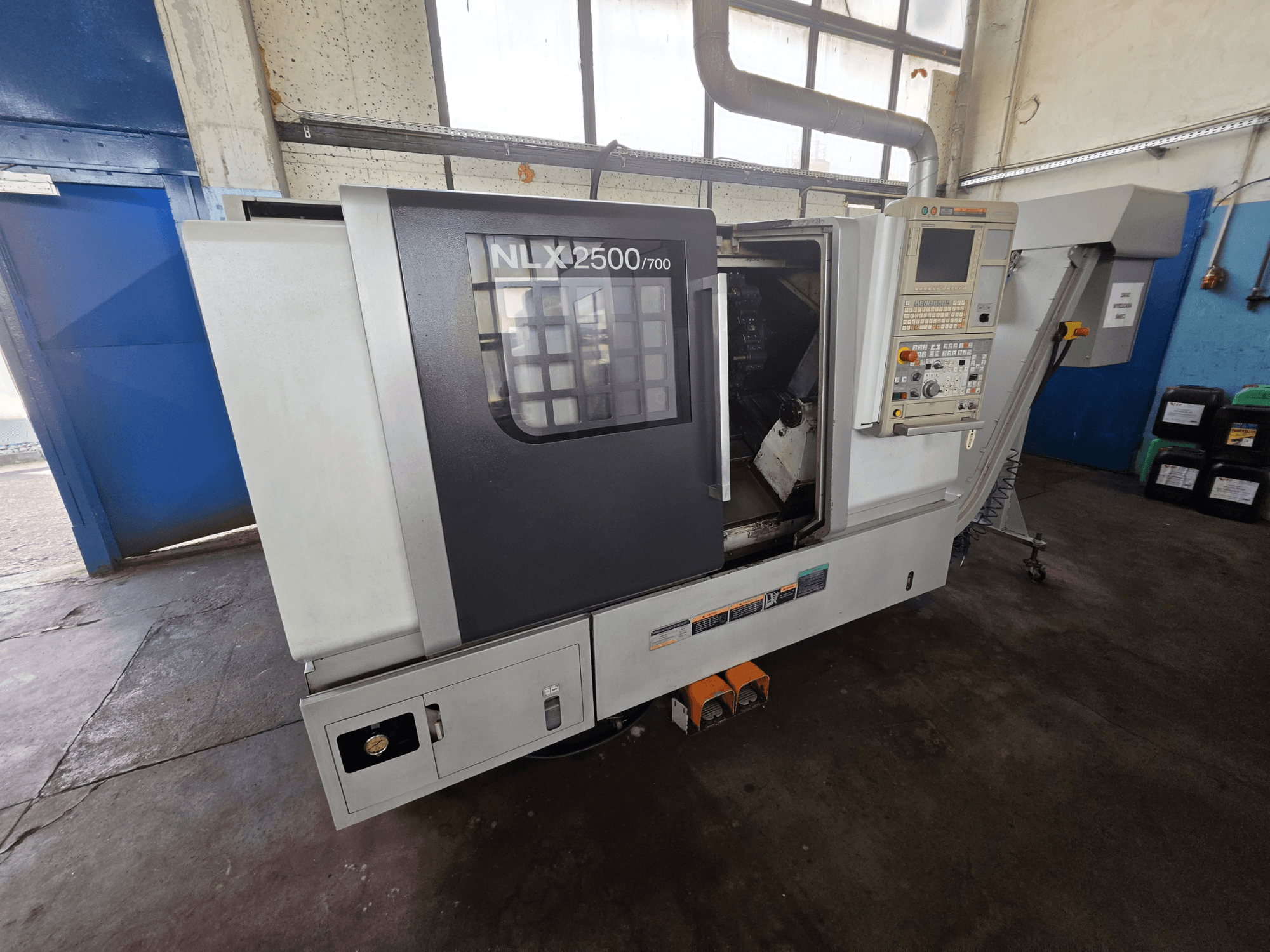 DMG MORI NLX 2500/700 horizontalios tekinimo staklės, vaizdas iš šono, kuriame matomas valdymo skydas ir apdirbimo zona.