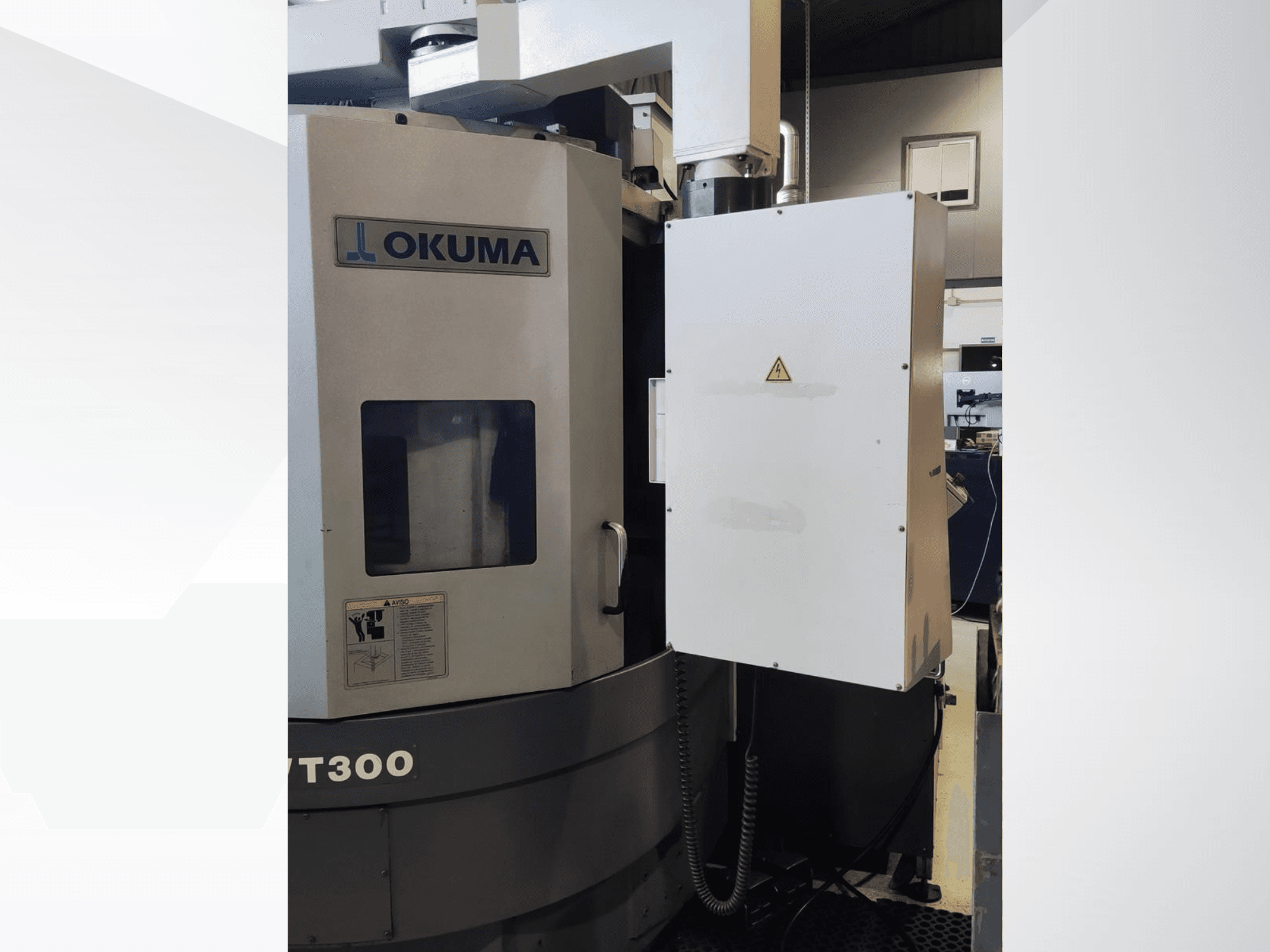 Vertikalios tekinimo staklės Okuma LVT300, vaizdas iš priekio, matomas valdymo skydelis ir pažymėtos saugos funkcijos.