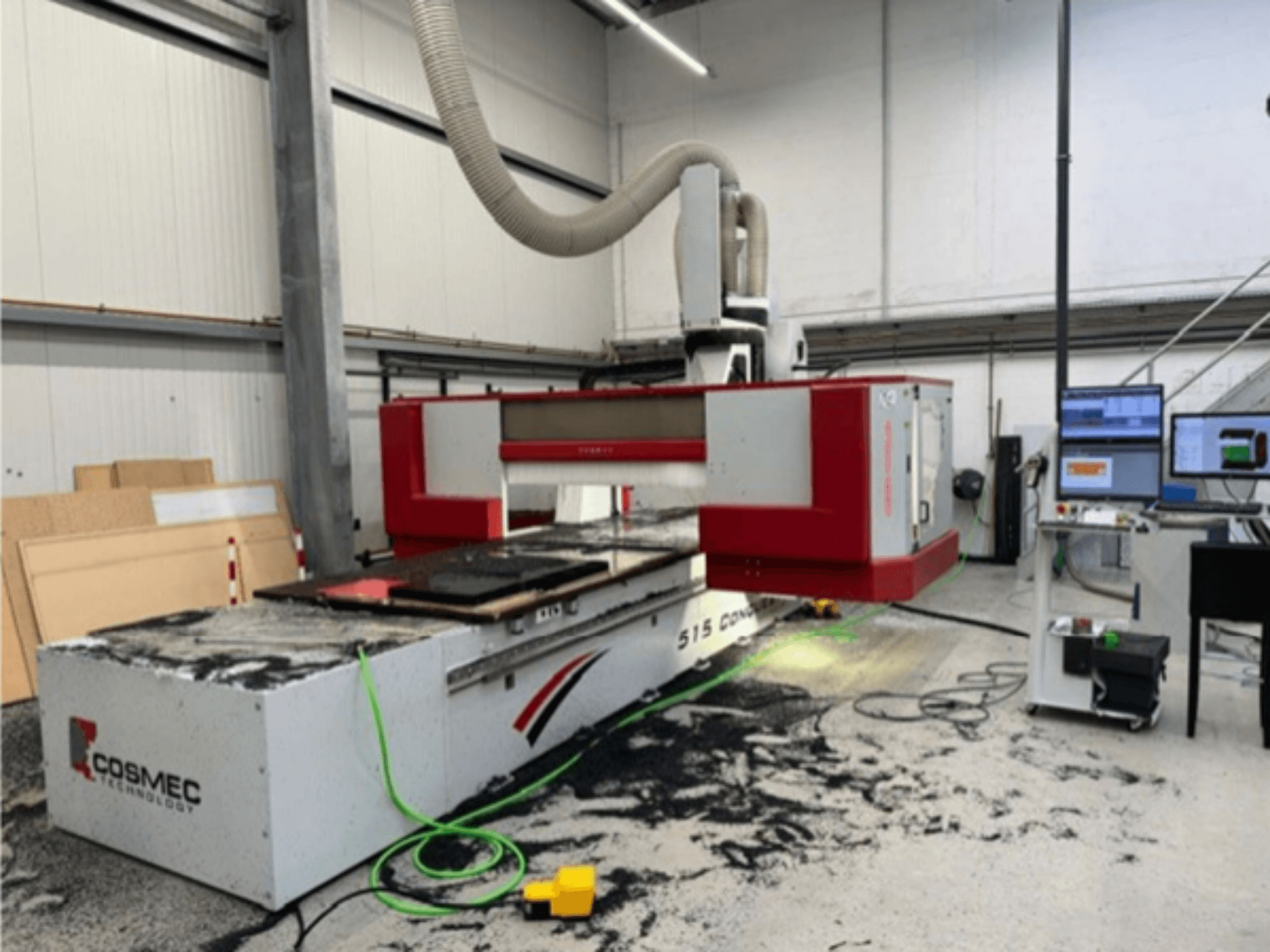 "Cosmec 515 CNC" staklės dirbtuvėse su kompiuterio terminalu, vaizdas iš priekio ir ant paviršiaus pasklidusios dulkės.