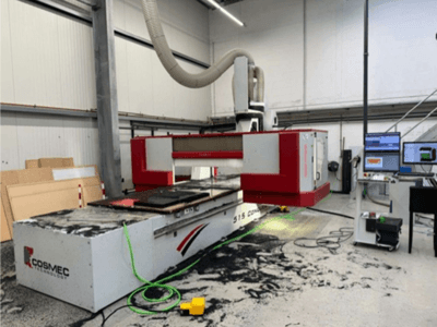 "Cosmec 515 CNC" staklės dirbtuvėse su kompiuterio terminalu, vaizdas iš priekio ir ant paviršiaus pasklidusios dulkės.