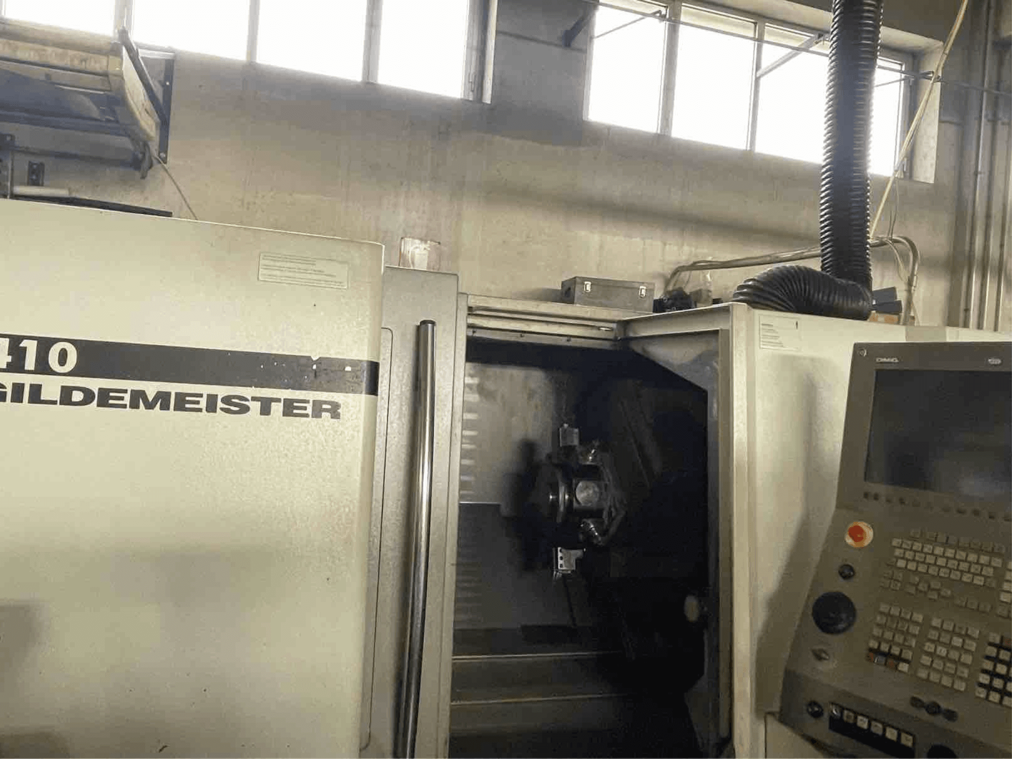 DMG CTX410 horizontalios tekinimo staklės, priekinis vaizdas, kuriame matomas valdymo skydelis ir viduje esantys apdirbimo komponentai.