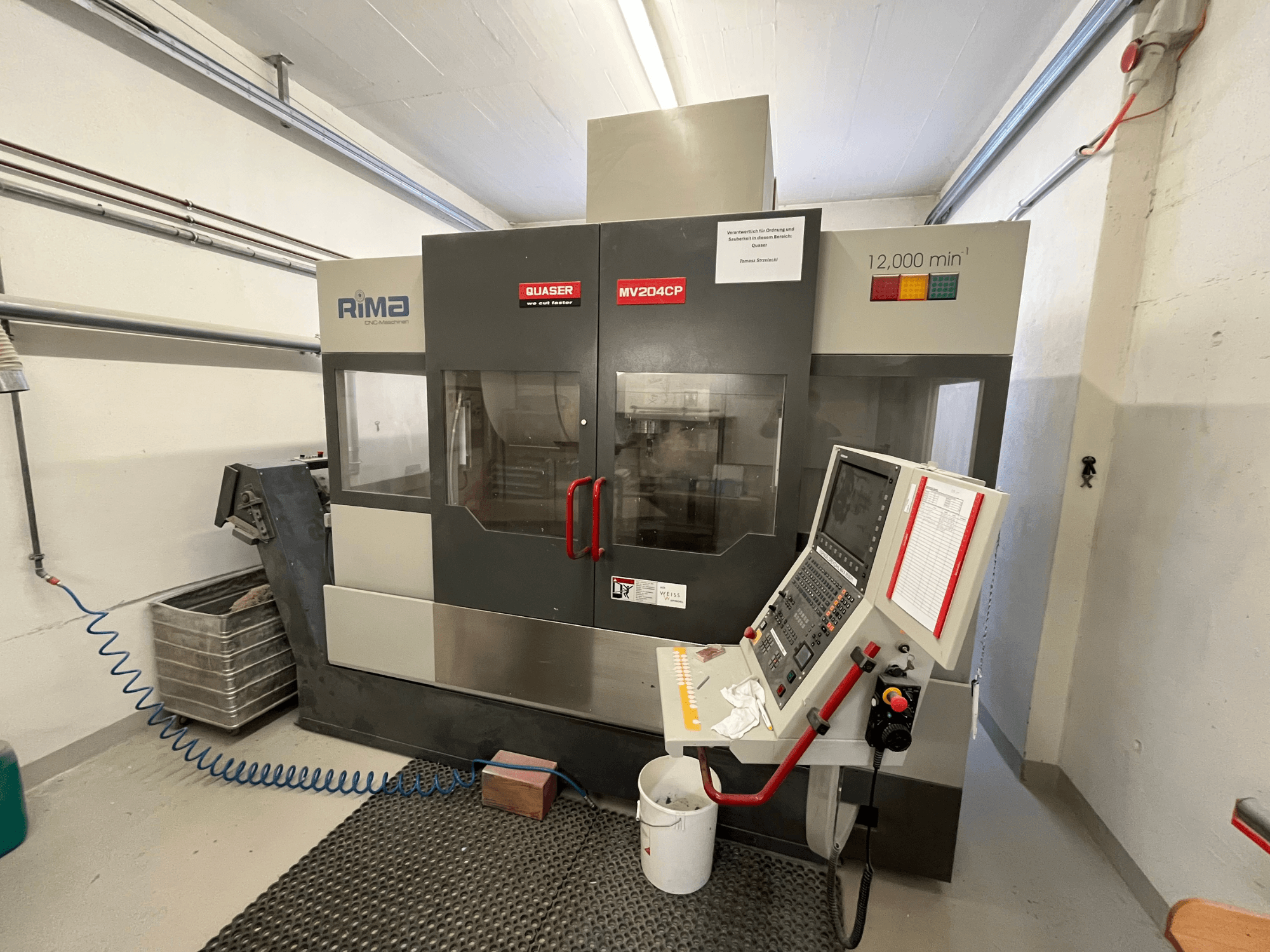 Vertikalusis apdirbimo centras "Quaser MV-204 CP" iš priekio, kuriame matomas valdymo skydelis ir darbinės detalės.