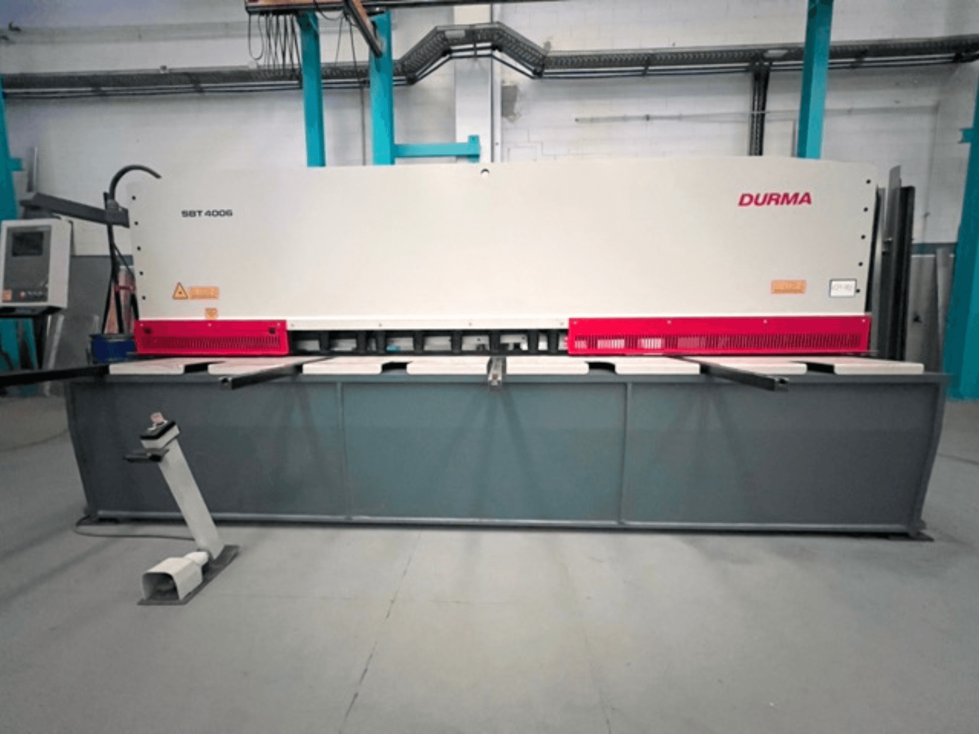 CNC kirpimo staklės "Durma SBT 4006" su pilku pagrindu ir raudonais akcentais, paruoštos darbui gamykloje.