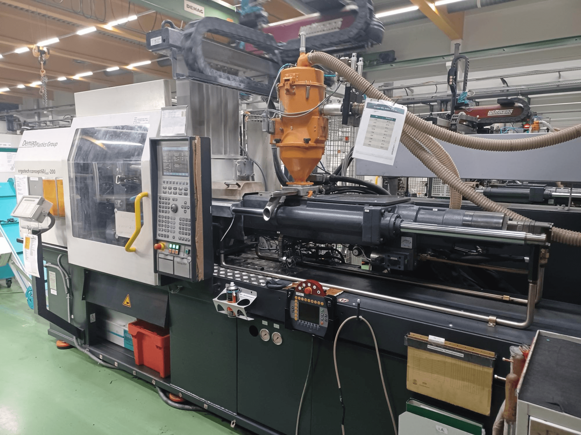 "Demag Ergotech 200" įpurškimo liejimo mašina, priekinis vaizdas, matomas valdymo skydelis, purkštukas ir darbiniai komponentai.