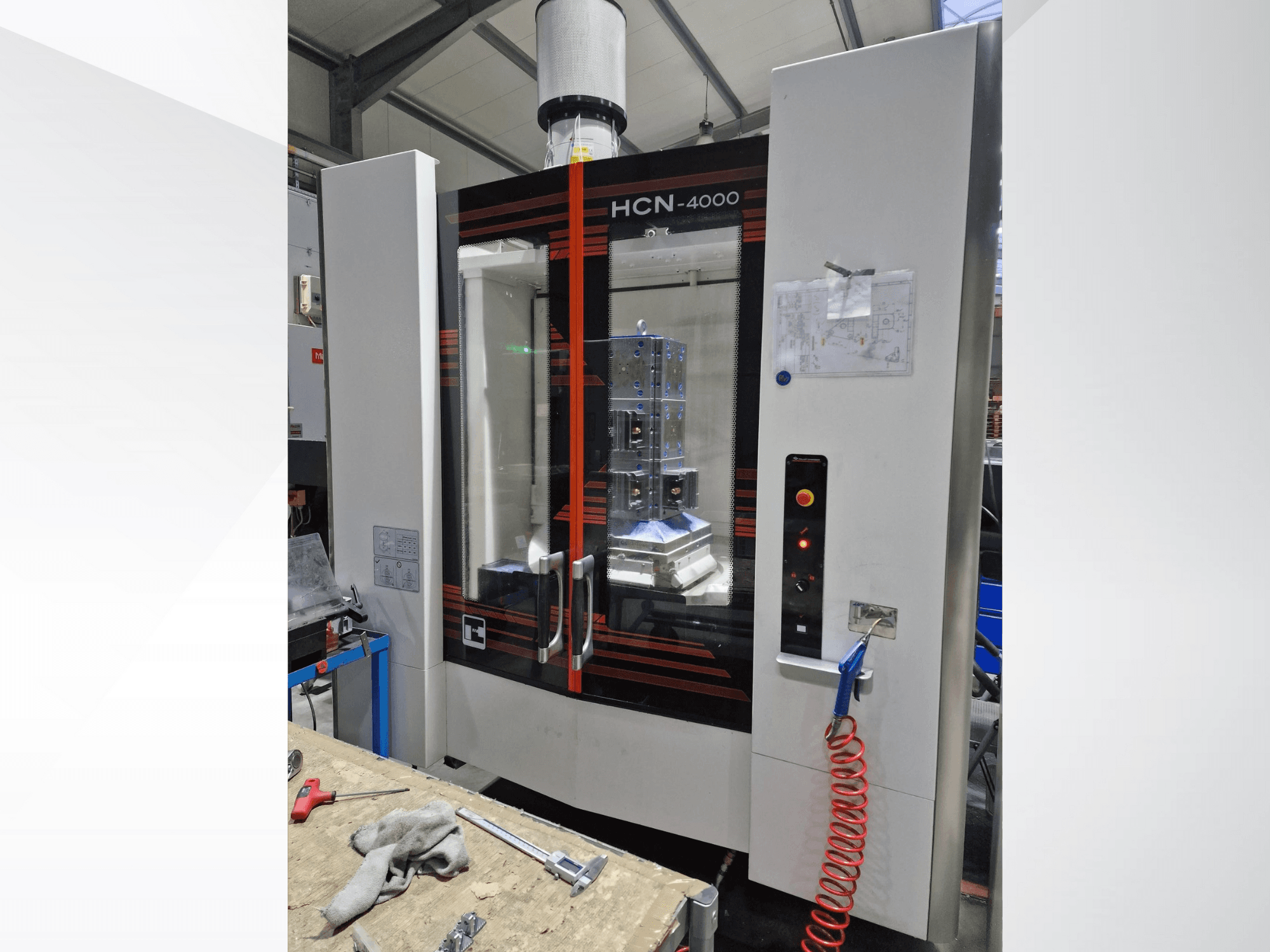 HCN-4000 CNC staklės iš priekio, su stikliniu skydeliu, valdymo skydeliu su mygtukais ir pridėtu brėžiniu.