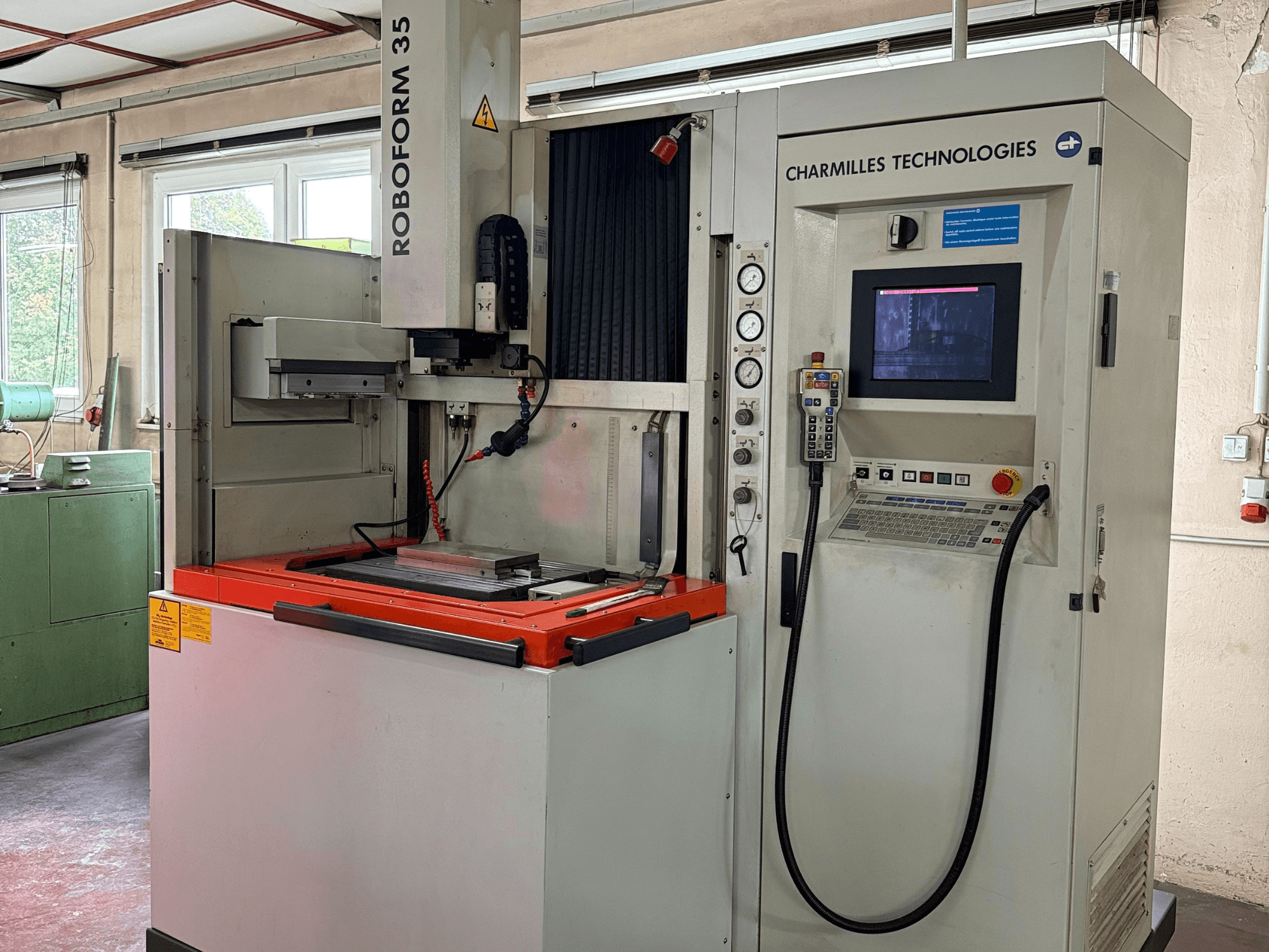 "Charmilles Technologies Roboforn 35" staklės, priekinis vaizdas, kuriame matyti valdymo skydelis, sumontuoti įrankiai ir saugos etiketės.