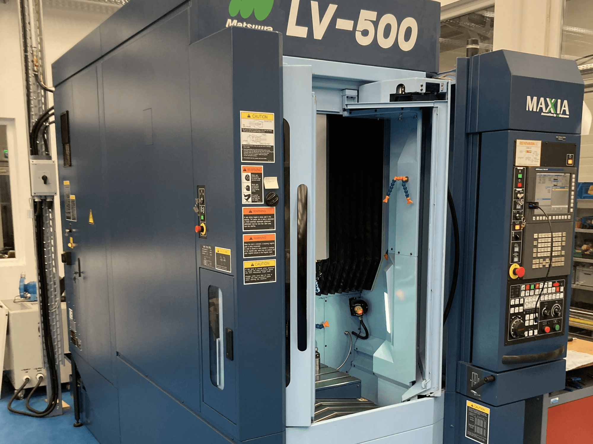 Matsuura LV-500 vertikalusis apdirbimo centras, parodytas iš priekio, su atviromis durelėmis ir valdymo skydeliu su mygtukais.