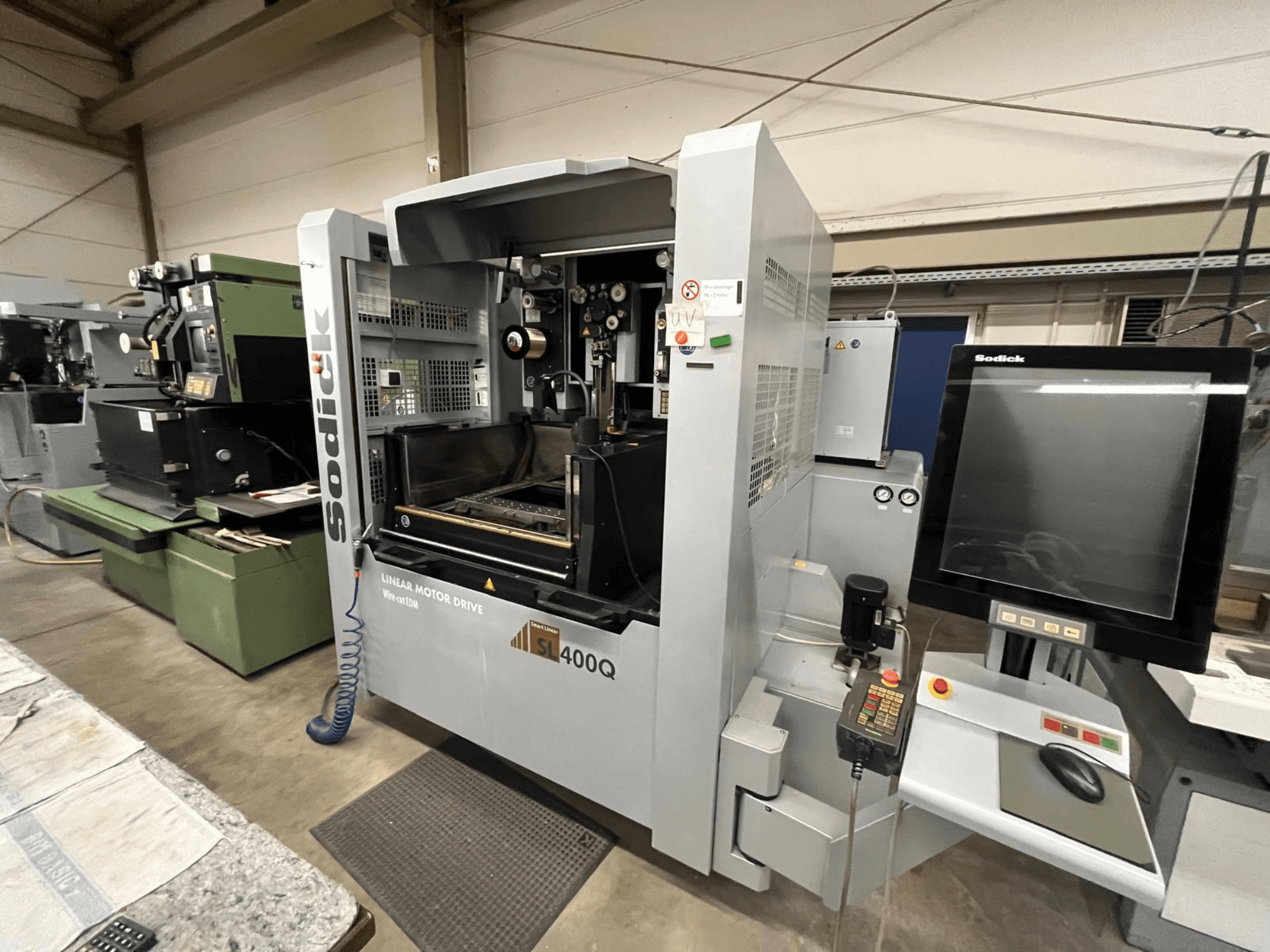 Sodick SL400Q CNC staklės su linijine variklio pavara, vaizdas iš priekio, skaitmeninis valdymo skydelis ir ekranas dirbtuvėse.