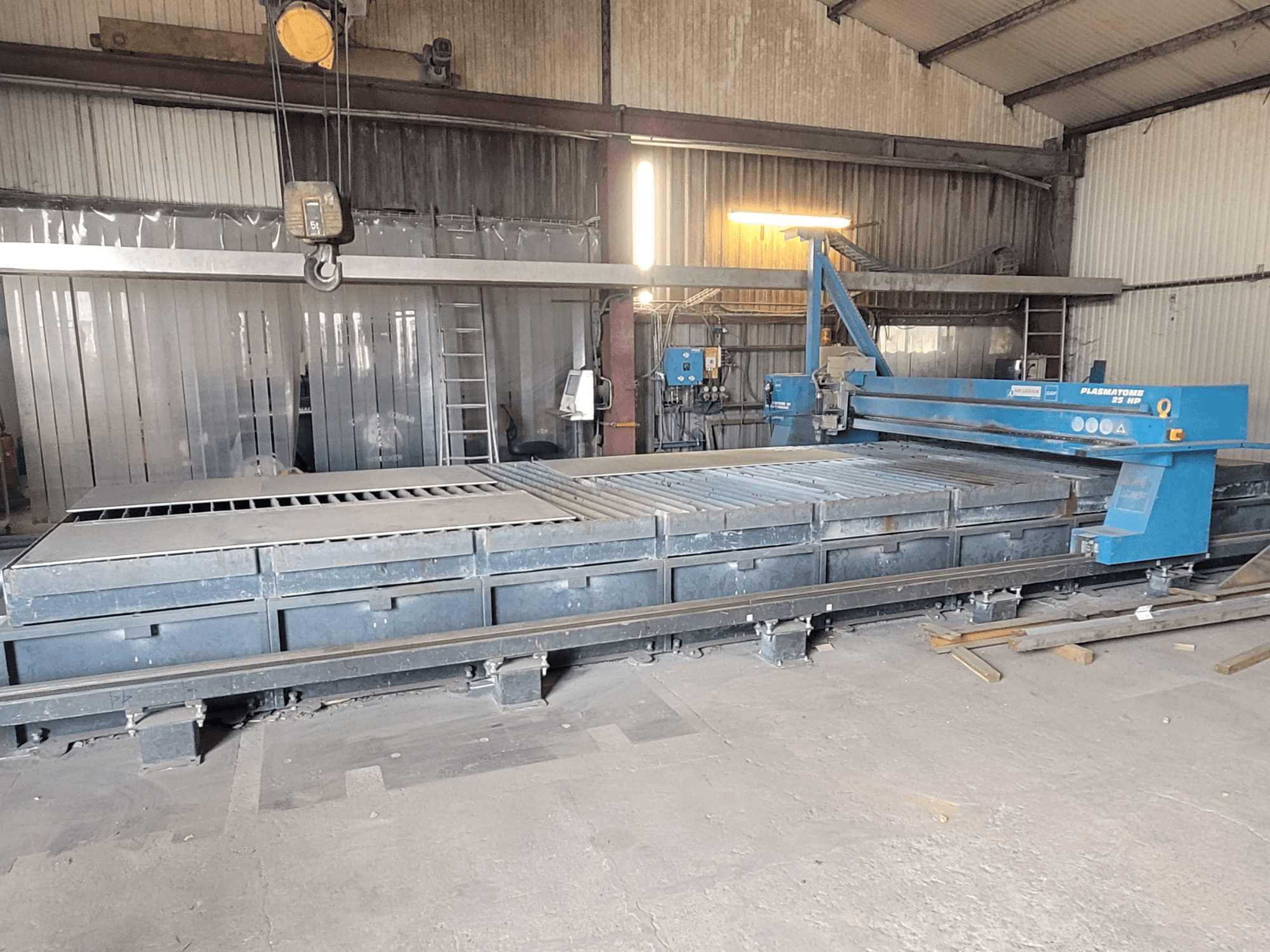 SAF Plasmatone 25Hp plazminio pjovimo staklės, šoninis vaizdas, kuriame matyti pjovimo lova ir darbiniai komponentai pramoninėje aplinkoje.