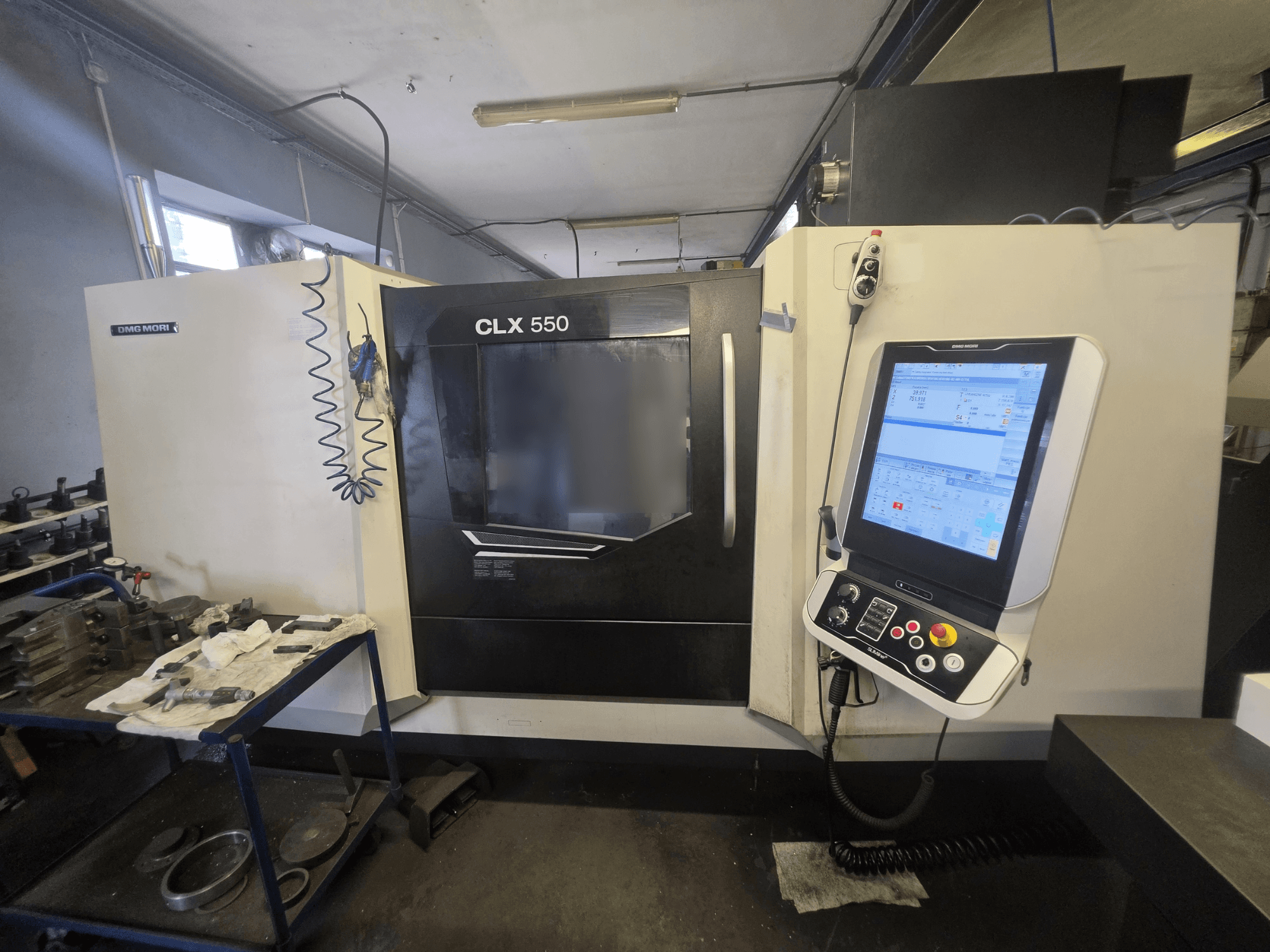 DMG MORI CLX 550 V3 horizontalus tekinimo staklės, vaizdas iš priekio, kuriame matomas valdymo pultas ir darbo erdvė su įrankiais.