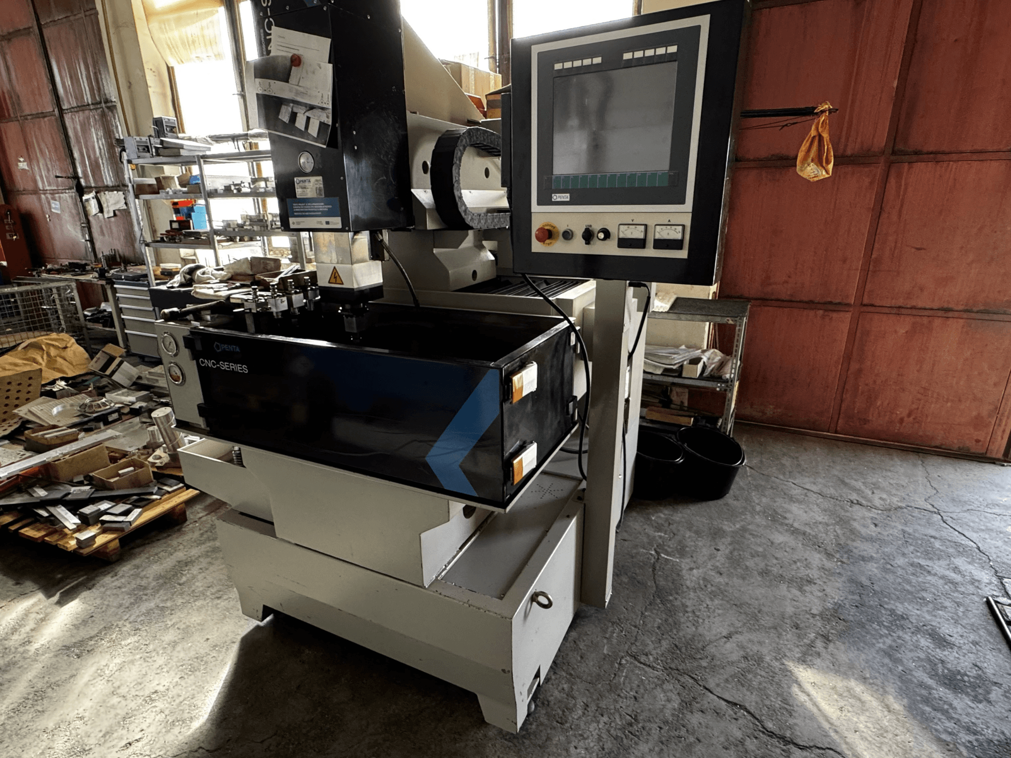 PENTA 433GS CNC štampavimo EDM staklės, vaizdas iš priekio. Rodomas valdymo skydelis, elektrodų laikiklis ir metalinis darbo stalas.