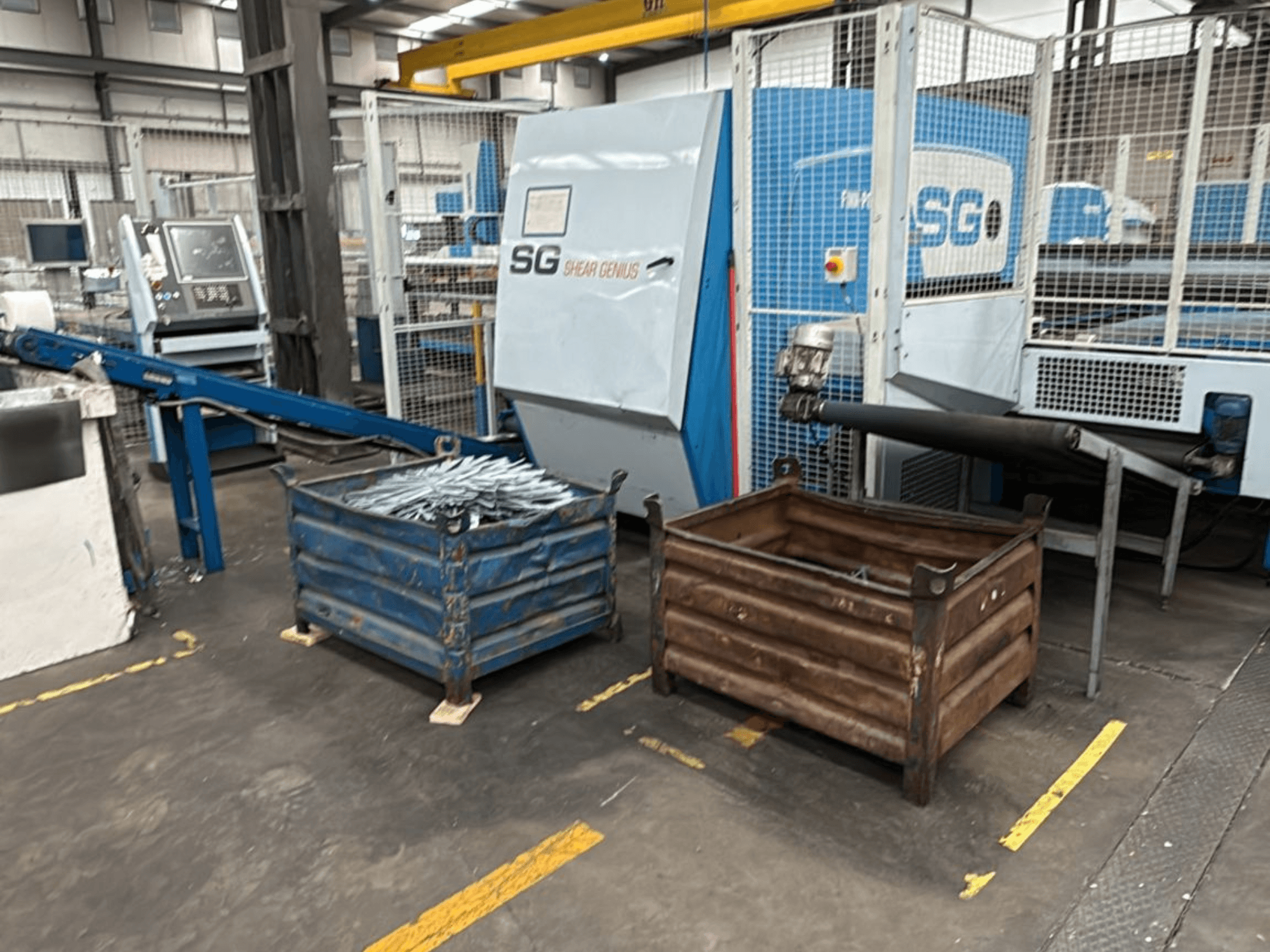 "Finn-Power SG6 12.61" perforavimo ir lenkimo staklės, vaizdas iš priekio su šalia esančiais metaliniais konteineriais dirbtuvėse.