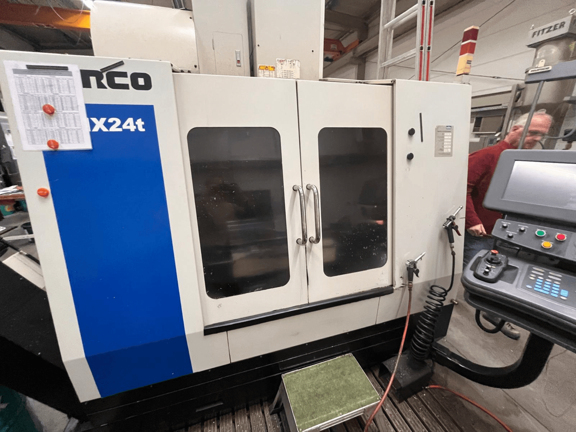 Hurco vertikalusis apdirbimo centras, VX24t modelis, parodytas iš priekio su valdymo skydeliu ir permatomomis durelėmis.