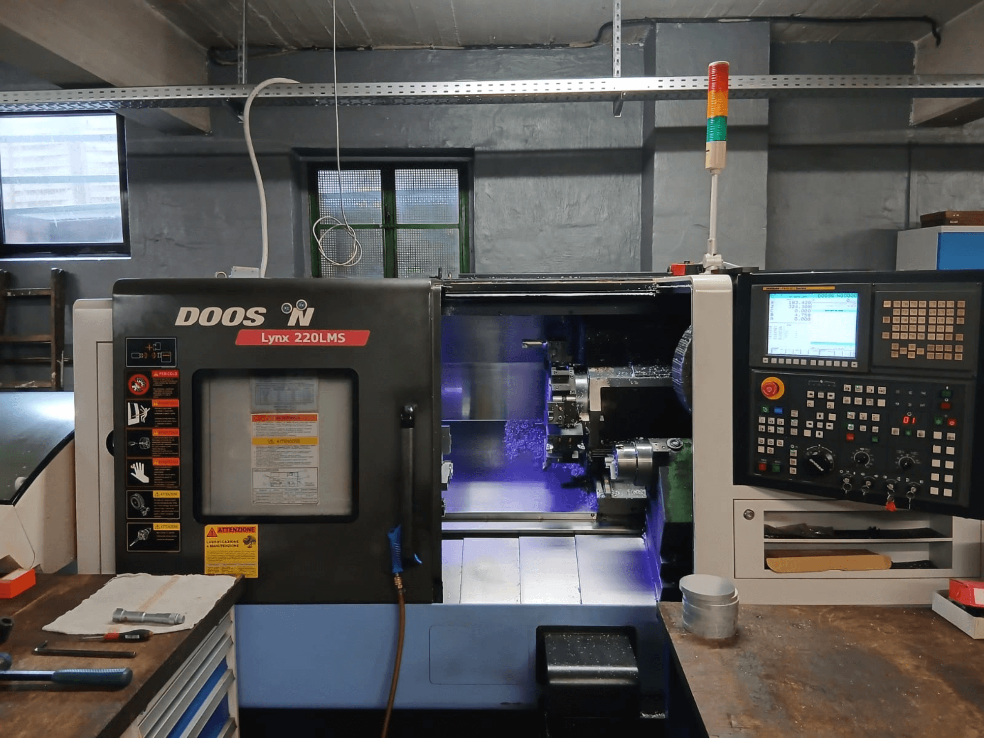 „DOOSAN Lynx 220 LMS“ horizontalioji tekinimo staklė, vaizdas iš priekio, kuriame matomas valdymo pultas ir apdirbimo zona.