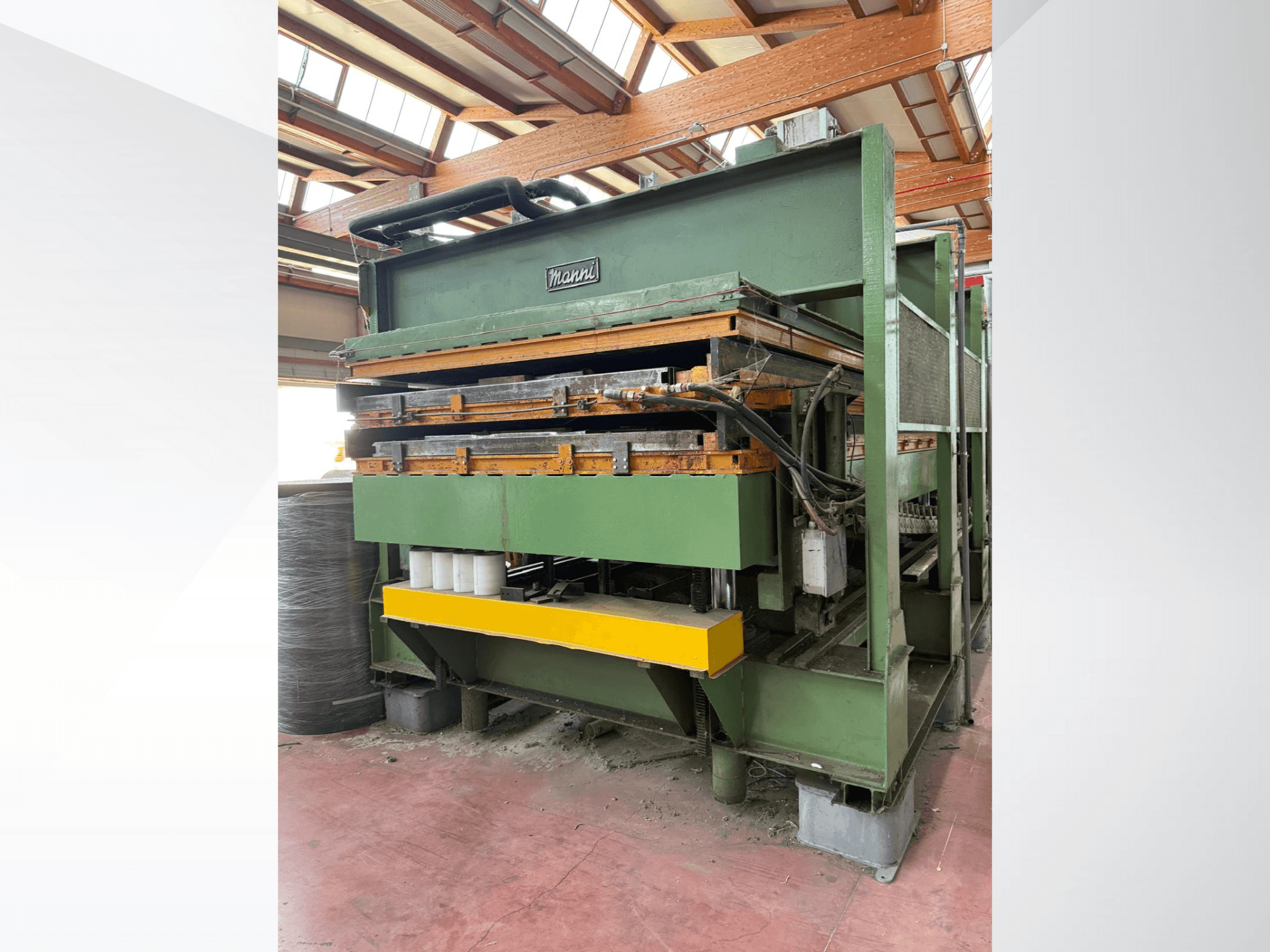"Manni" hidraulinis presas, vaizdas iš šono, žalias metalinis korpusas, geltonas pagrindas, matomos kelios hidraulinės linijos.