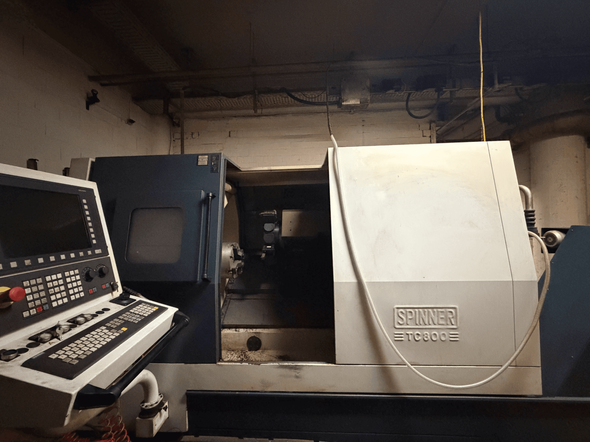 Horizontalios tekinimo staklės SPINNER TC800, vaizdas iš priekio, matomas valdymo skydelis ir šiek tiek atidengtas staklių vidus.