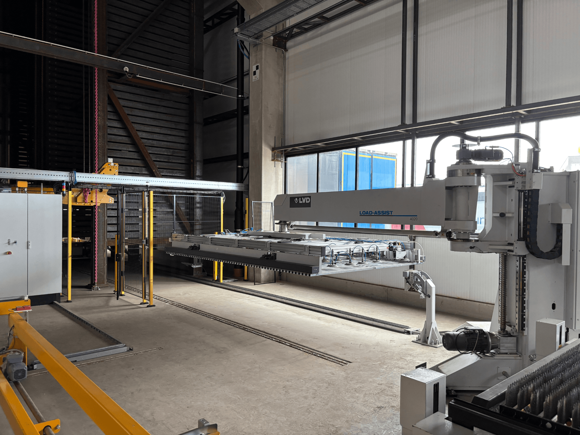 LVD Load-Assist 4020 automatizavimo įrangos vaizdas iš priekio, didelėje darbo erdvėje matoma roboto ranka ir krovimo sistema.