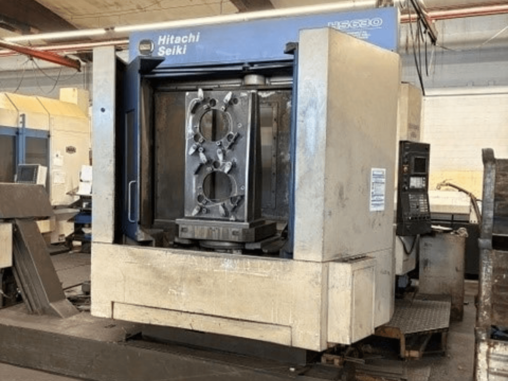 „Hitachi Seiki HS630“ horizontalus apdirbimo centras, vaizdas iš priekio, kuriame matomas apdirbamas ruošinys ir valdymo pultas.