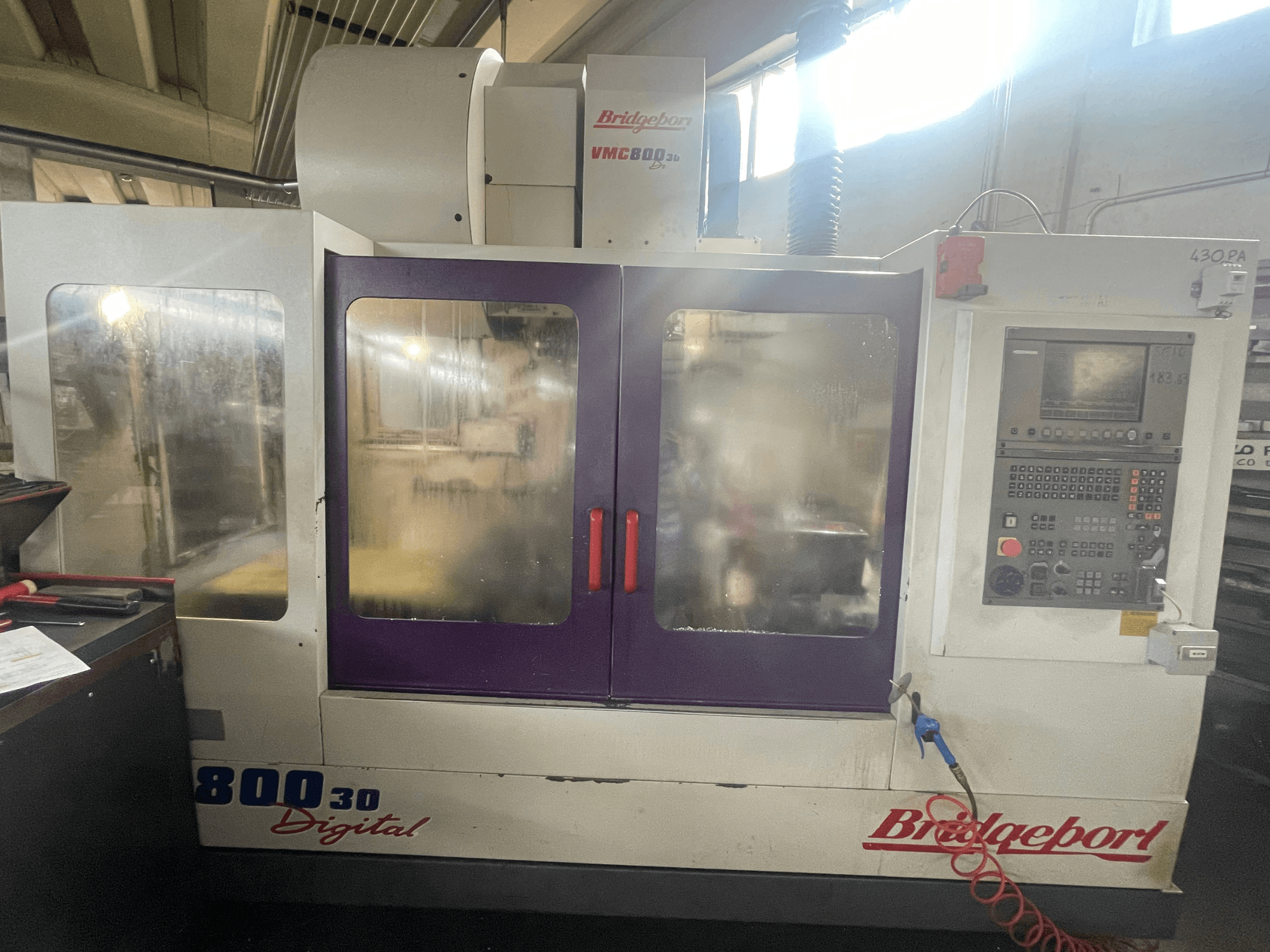 Vertikalusis apdirbimo centras „Bridgeport VMC 800/30“, vaizdas iš priekio su valdymo pultu ir dideliais stebėjimo langais.