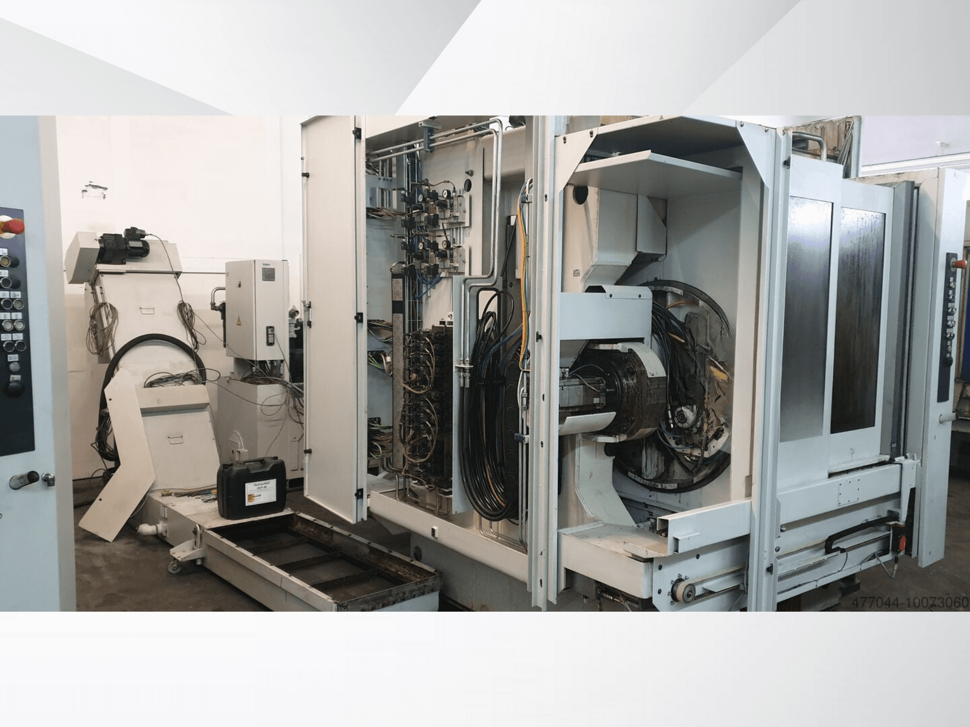 Pramoninės mašinos su matomais laidais, valdymo skydeliu ir mechaniniais komponentais; sudėtingos mašinos vaizdas iš šono.