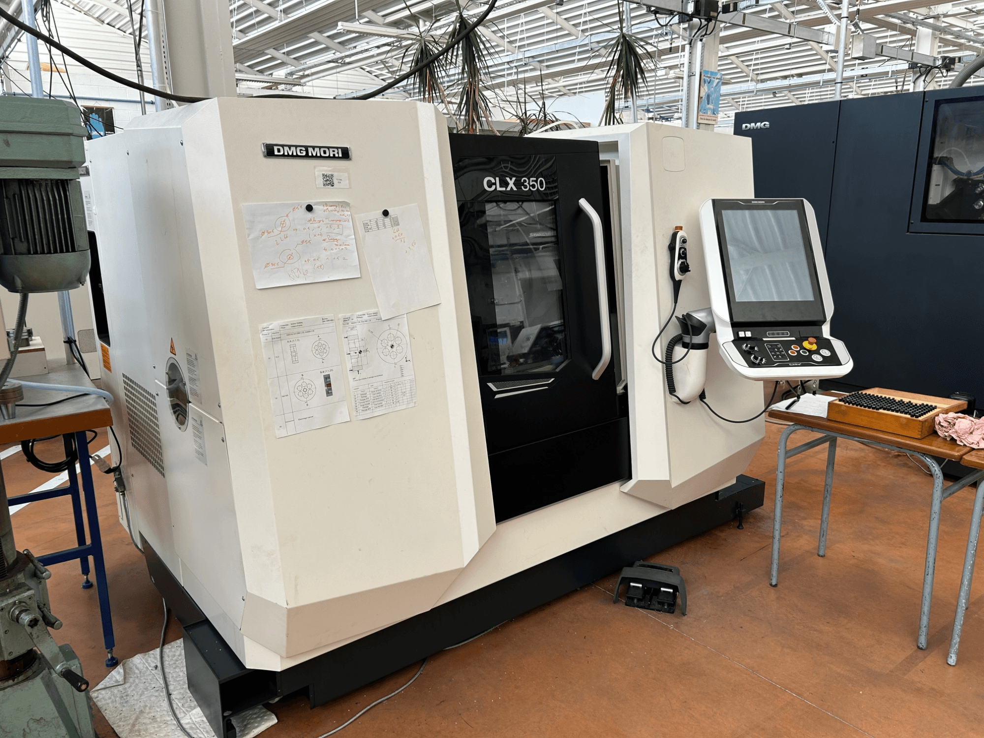 DMG MORI CLX 350 V4 horizontalus tekinimo staklės, vaizdas iš priekio su valdymo skydu ir pridėtais techniniais dokumentais.
