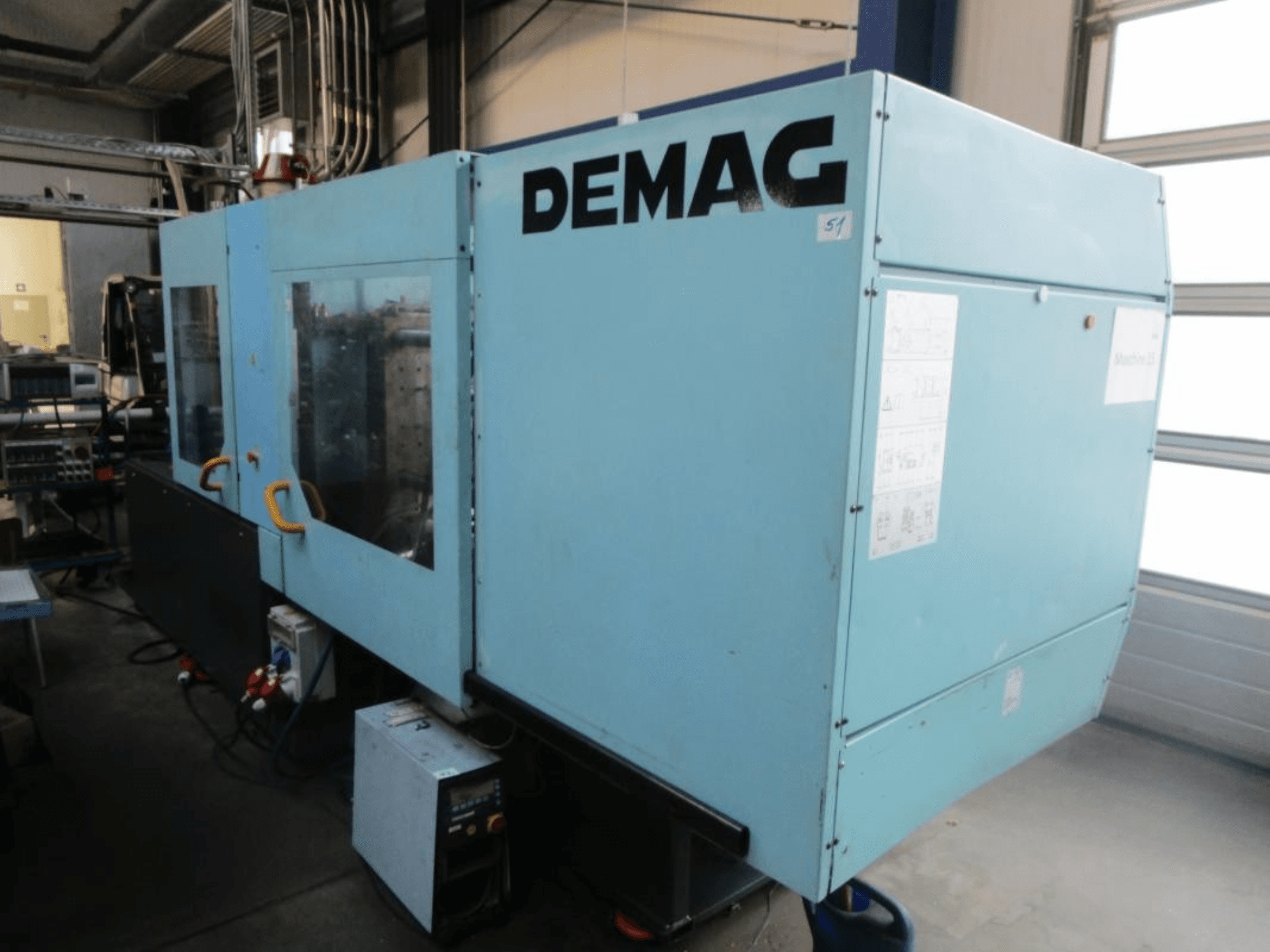 „DEMAG Ergotech 150-610 Viva“ hidraulinio liejimo staklių vaizdas iš priekio, kuriame matomas valdymo skydas ir rankenos.